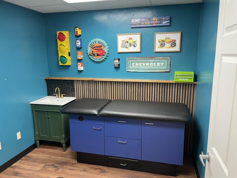 A peaceful medical exam room at Restoration Health featuring calming blue walls and a modern examination table, designed to provide a serene and professional environment for patient care.