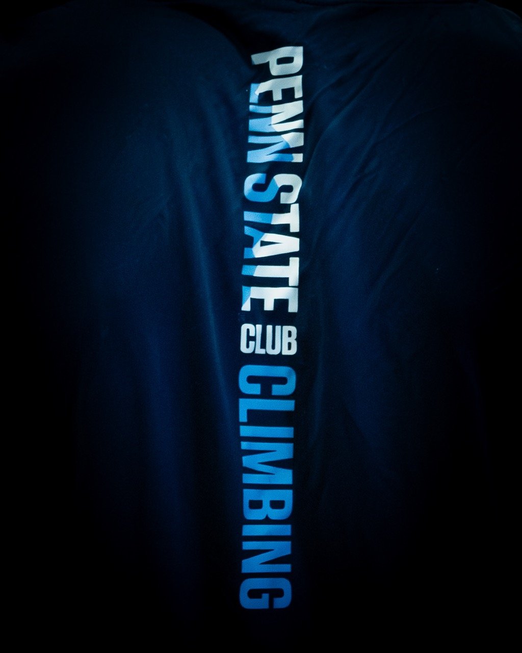 brand photography, "penn state club climbing" on a navy blue jersey