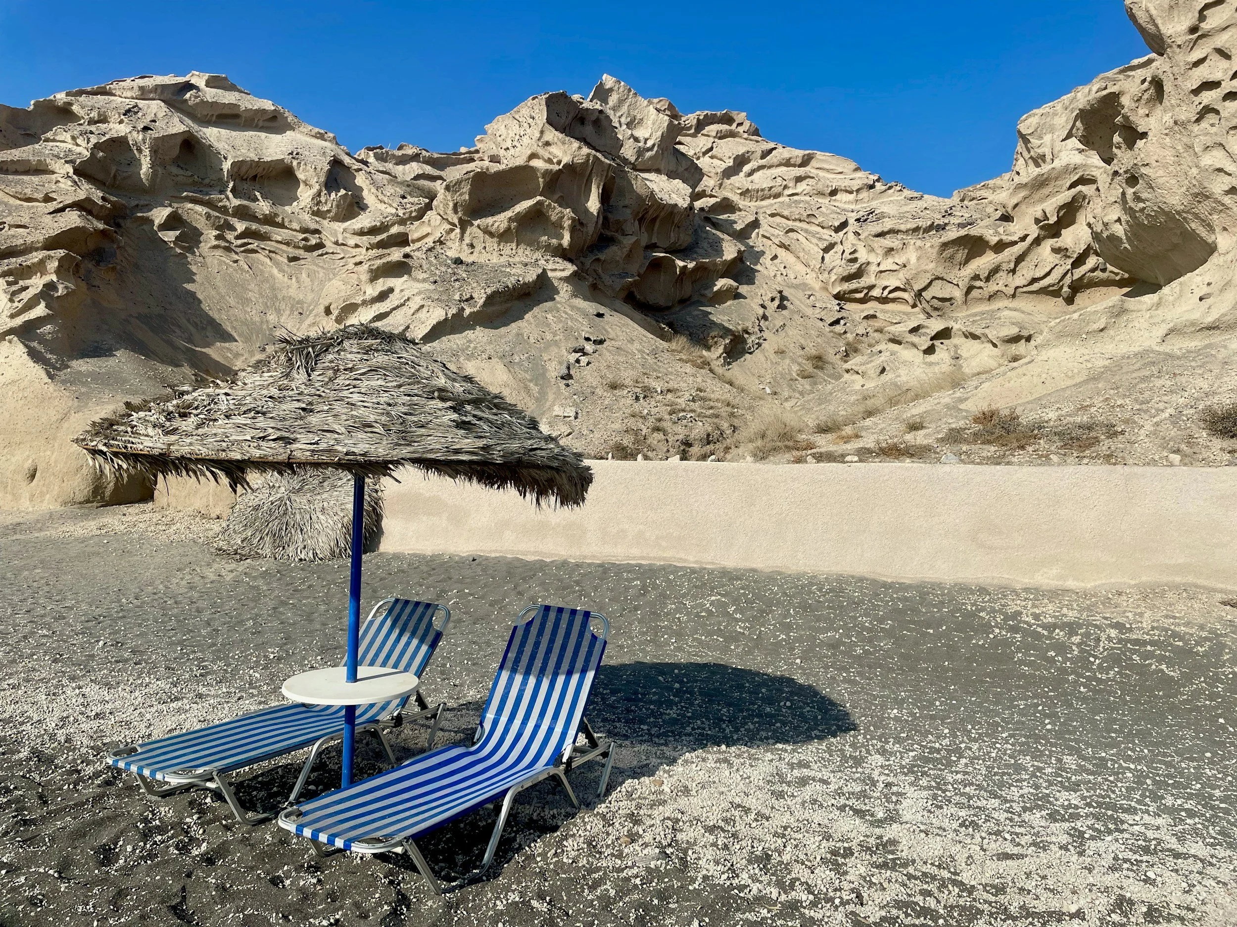 blue and shite striped sun loungers on the beach