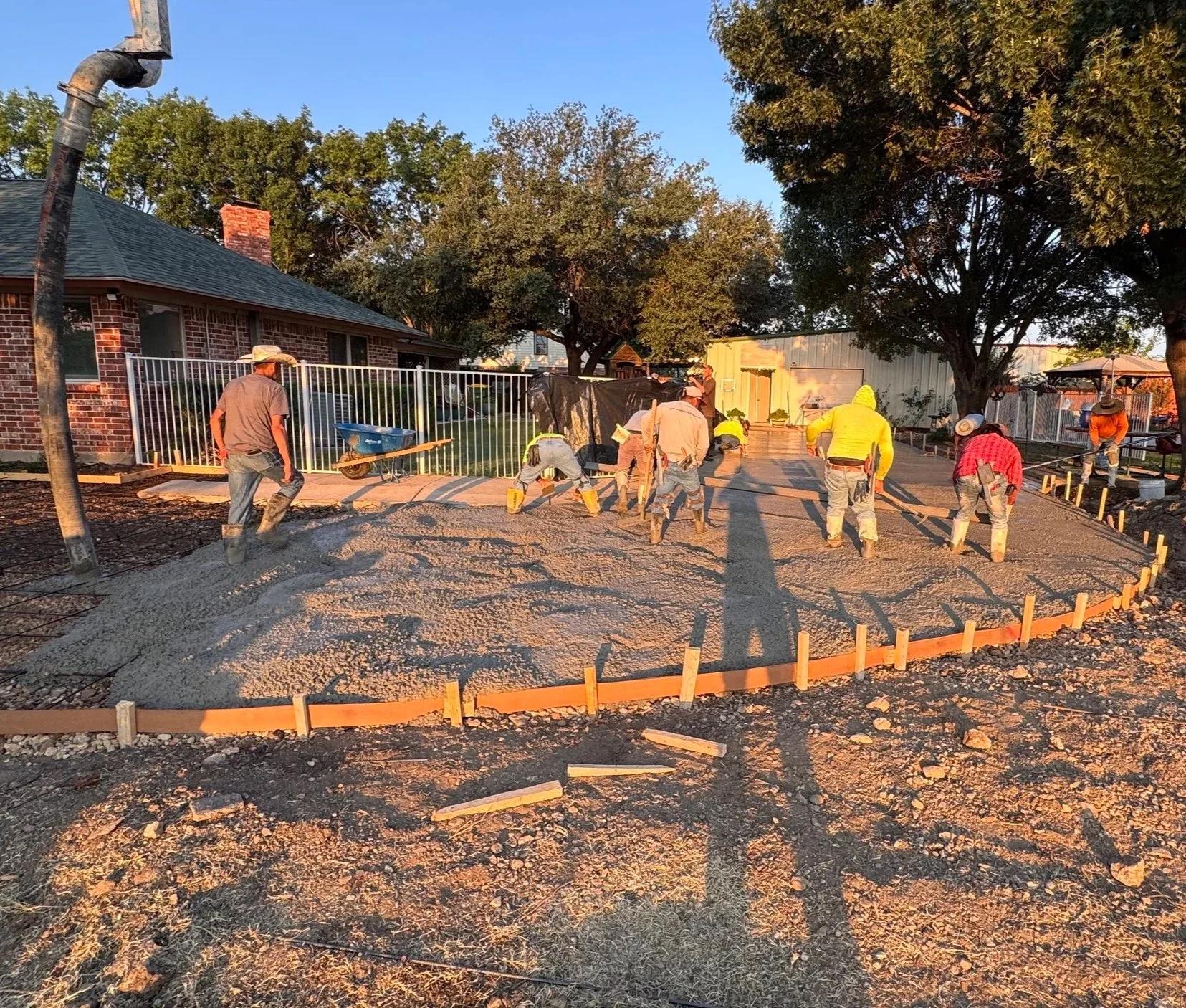 Raythorn Construction crew pouring and leveling a residential concrete driveway in North Richland Hills, Texas — expert concrete contractors specializing in flatwork, paving, and turnkey sports court foundations across DFW.