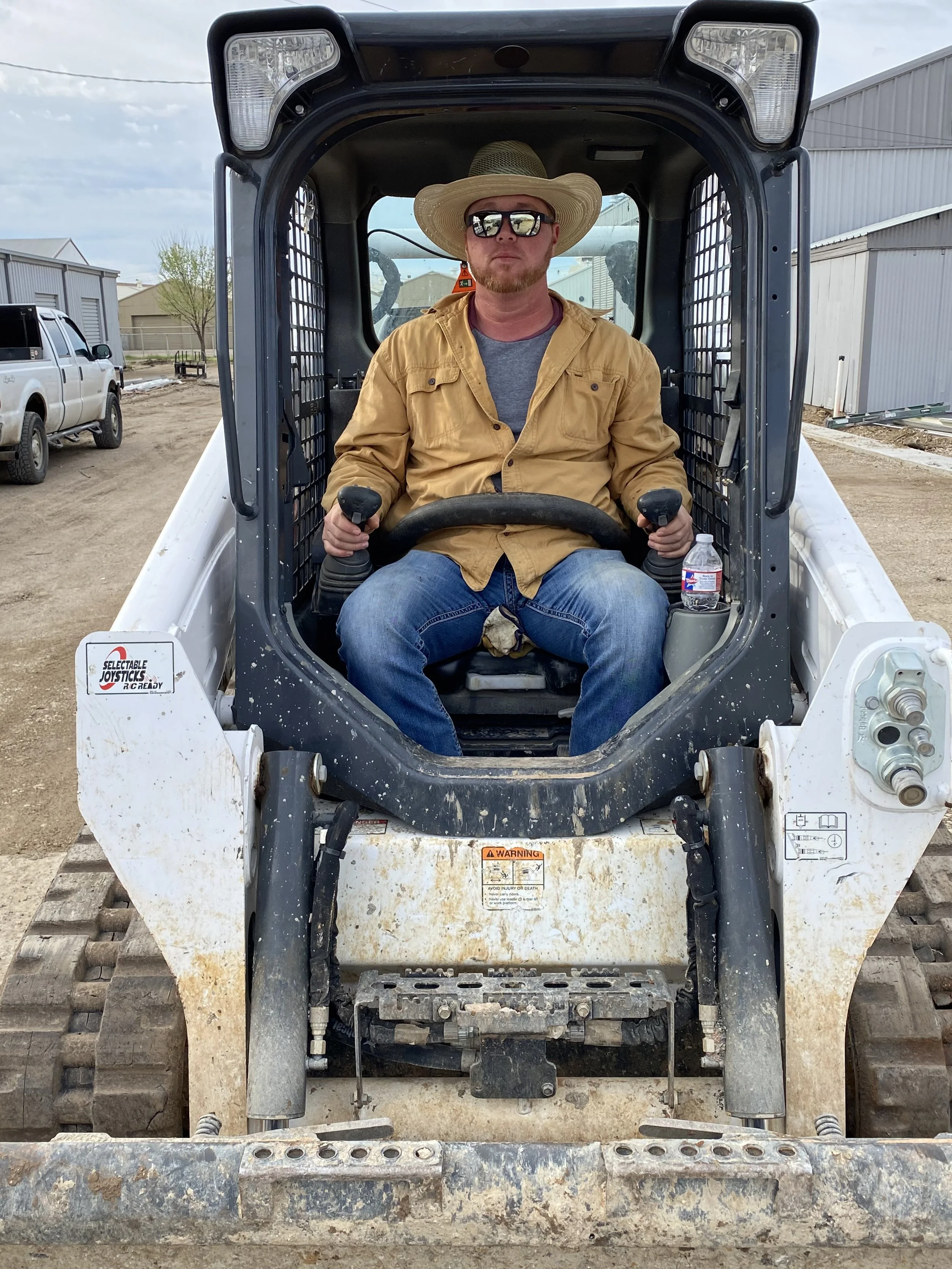 Nathan Ray, owner of Raythorn Construction, operating a skid steer on site in Fort Worth, Texas — a hands-on leader dedicated to quality, precision, and getting the job done right.