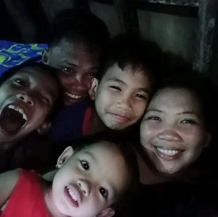 Group of five people smiling and making funny faces in a close-up selfie.