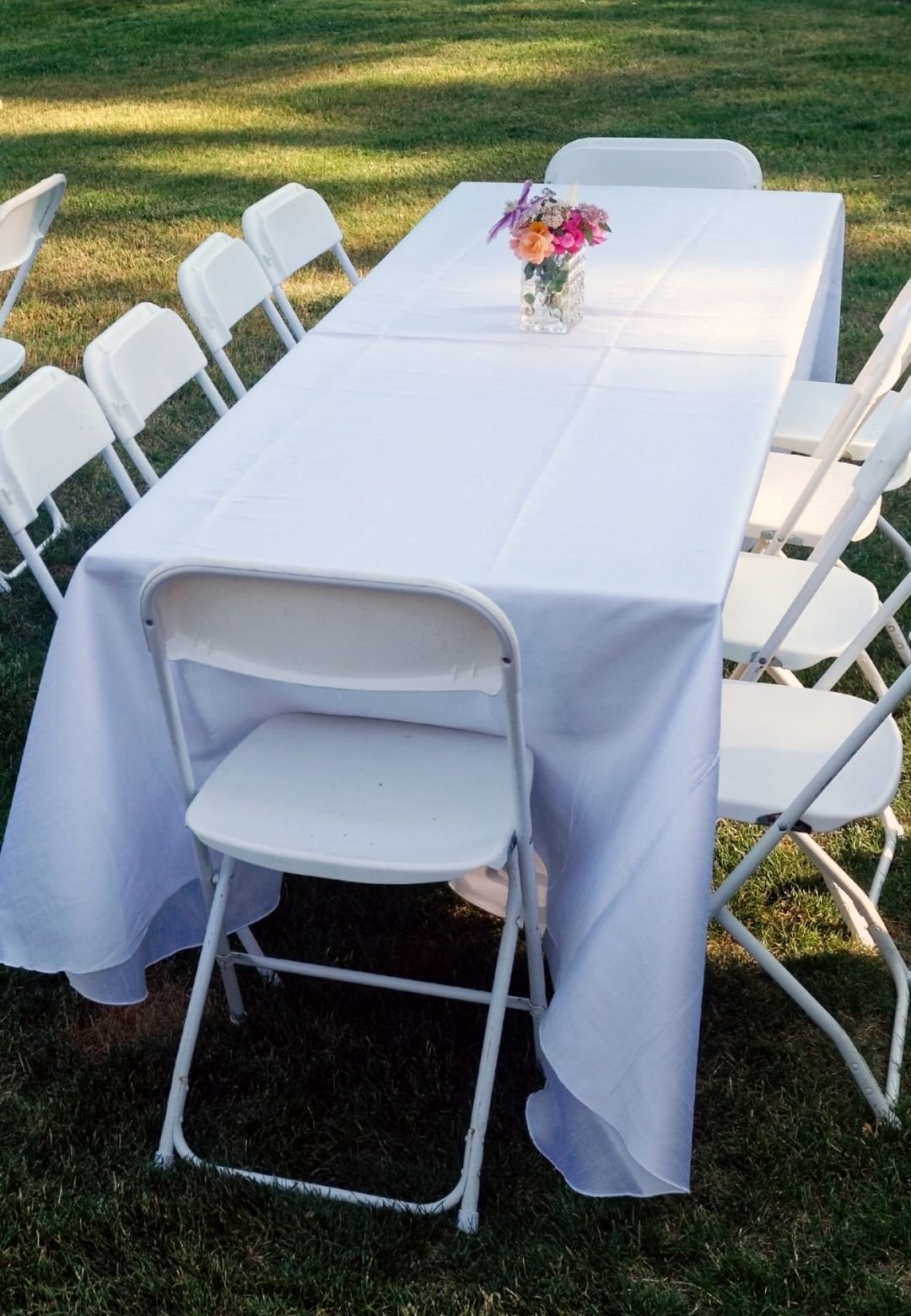 White folding table and chair rental setup for weddings, parties, and outdoor events