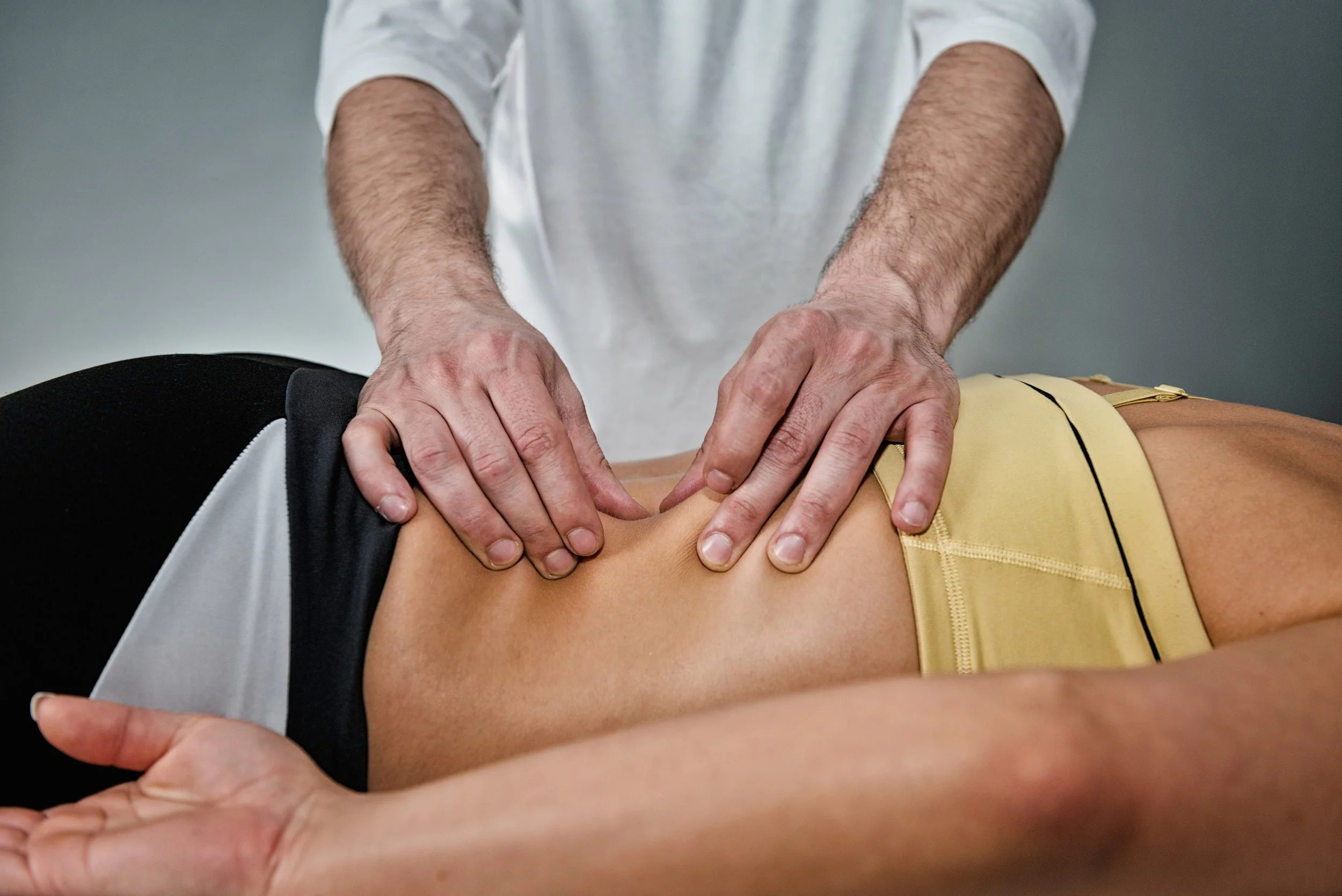 A person receiving a chiropractic adjustment or massage on their back from a healthcare professional.