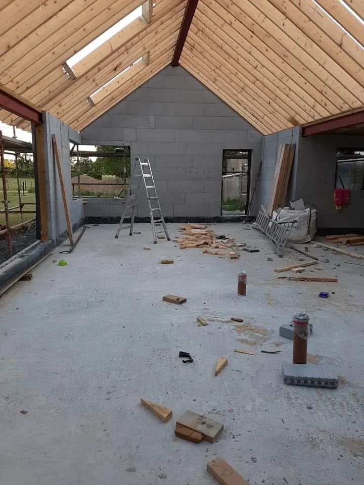Interior of an ICF house under construction with an unfinished timber roof