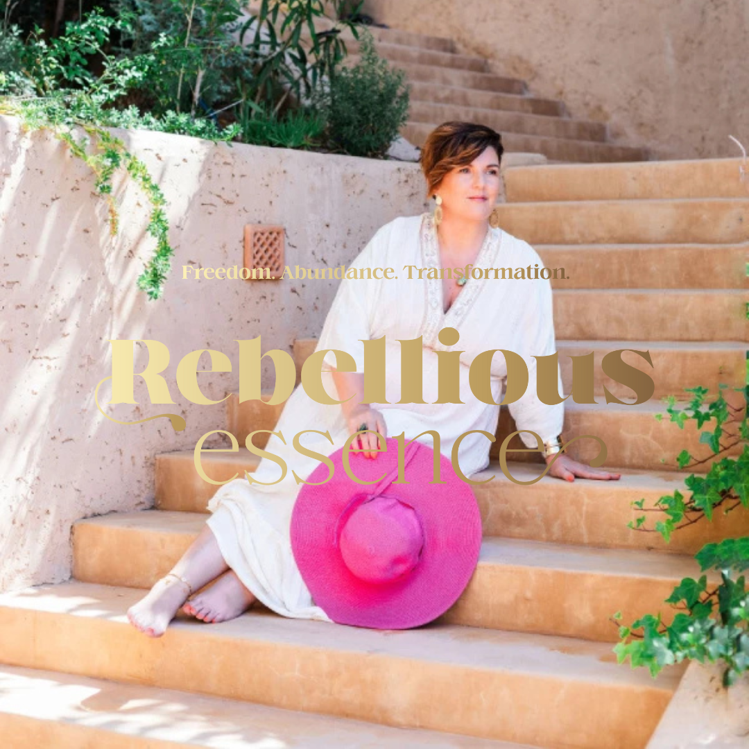 A woman sitting on outdoor stone steps, holding a large pink sunhat, with greenery and stairs in the background, and the words 'Rebellious essence' and 'Freedom. Abundance. Transformation.' overlaid.