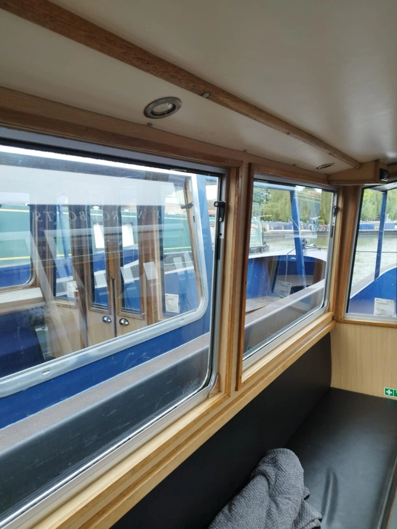 Inside a boat with large windows looking out onto moored boats.