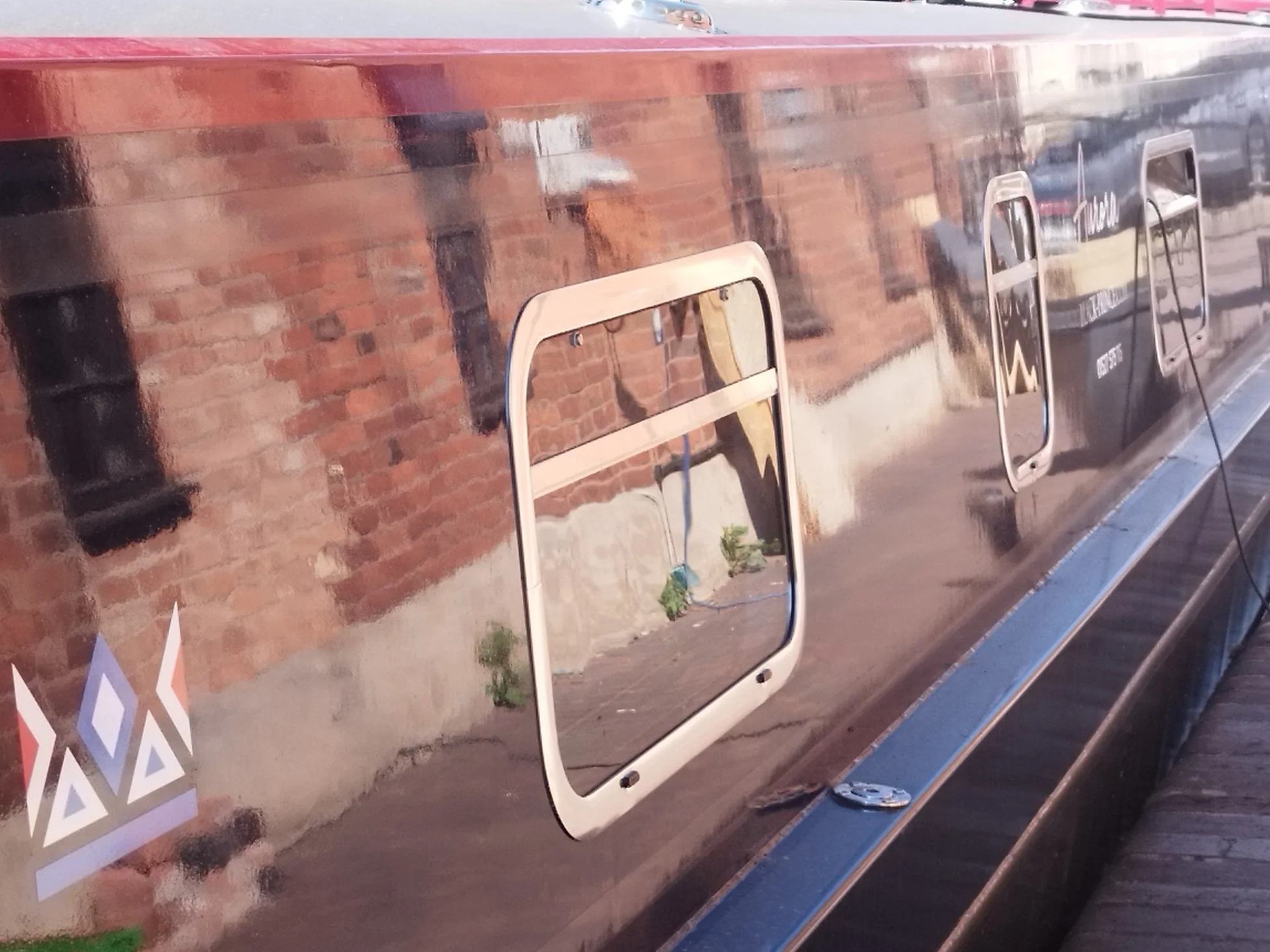 Close-up of a shiny anodised windows on a Black Prince Hire narrowboat.