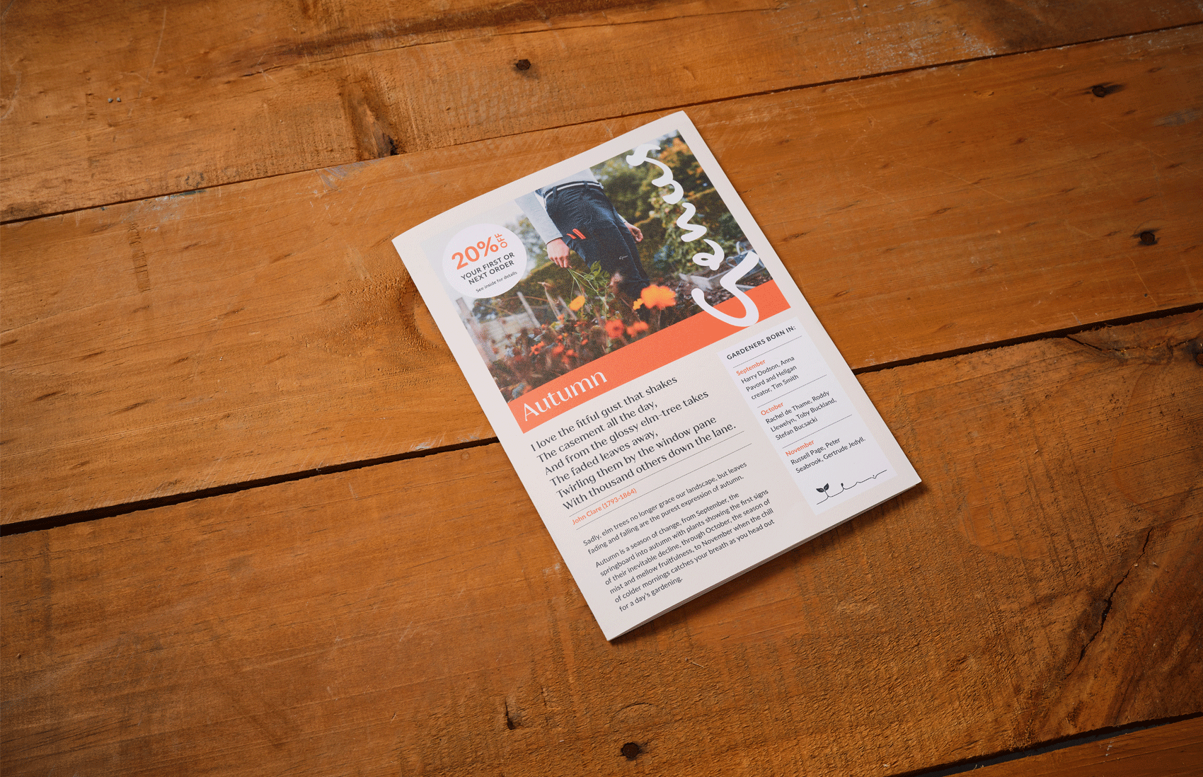 A flyer on a wooden surface advertising a 20% discount with a photo of a person in a garden during autumn, displaying colorful fall foliage. The flyer includes seasonal information, poem, and signatures.