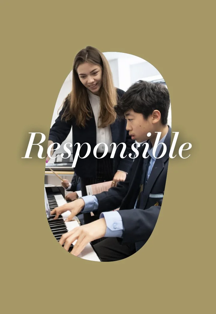 A young female teacher or instructor assisting a male student playing the piano in a classroom setting.