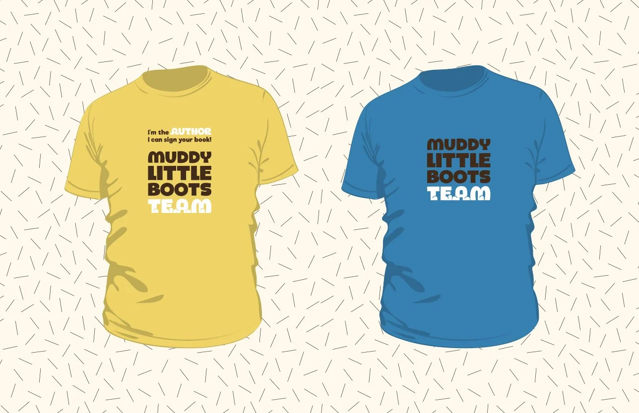 Two T-shirts hanging against a patterned background. The yellow shirt has text that says "I'm the AUTHOR I can sign your book!" above a logo that reads "MUDDY LITTLE BOOTS TEAM" in bold, with the word "TEAM" in white. The blue shirt displays only the "MUDDY LITTLE BOOTS TEAM" logo in the same style.