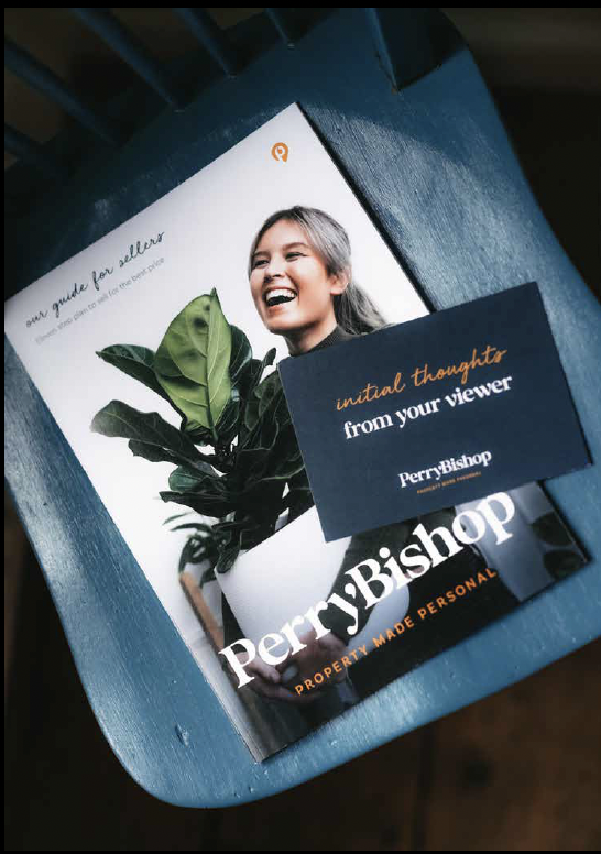 A PerryBishop real estate brochure titled 'an estate agent's guide for sellers' featuring a smiling woman with gray hair, a potted plant, and a blue card that reads 'initial thoughts from your viewer'.