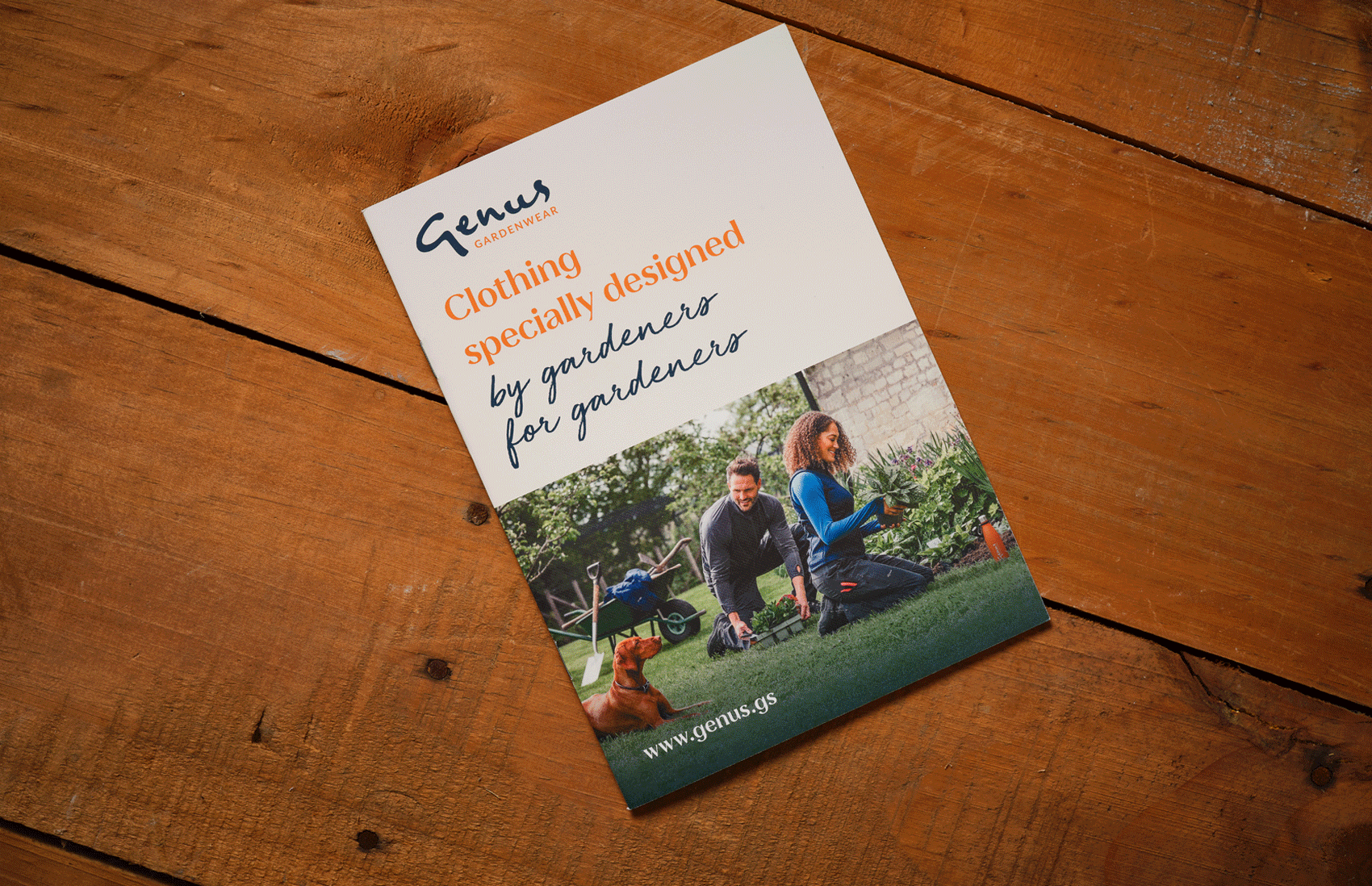 Brochure for Genus Gardenwear featuring a man and woman gardening with a small dog on a wooden surface.