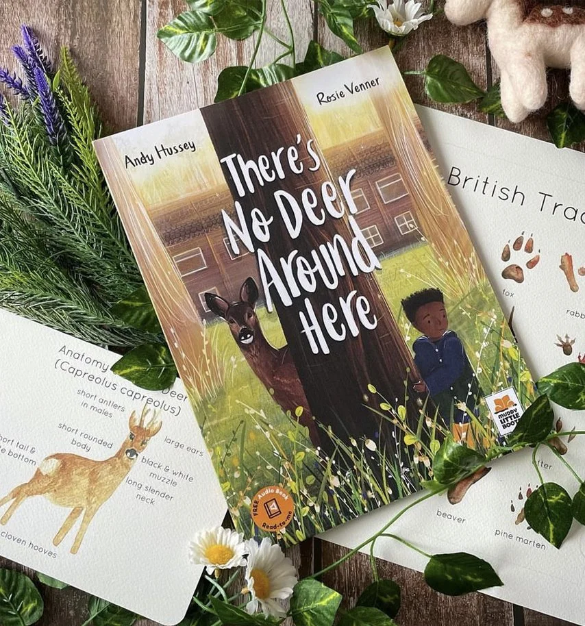 Children's book titled "There's No Deer Around Here" by Andy Hussey and Rosie Venner, featuring a deer and a boy on the cover, positioned among nature-themed decor including sprigs of greenery and flowers.