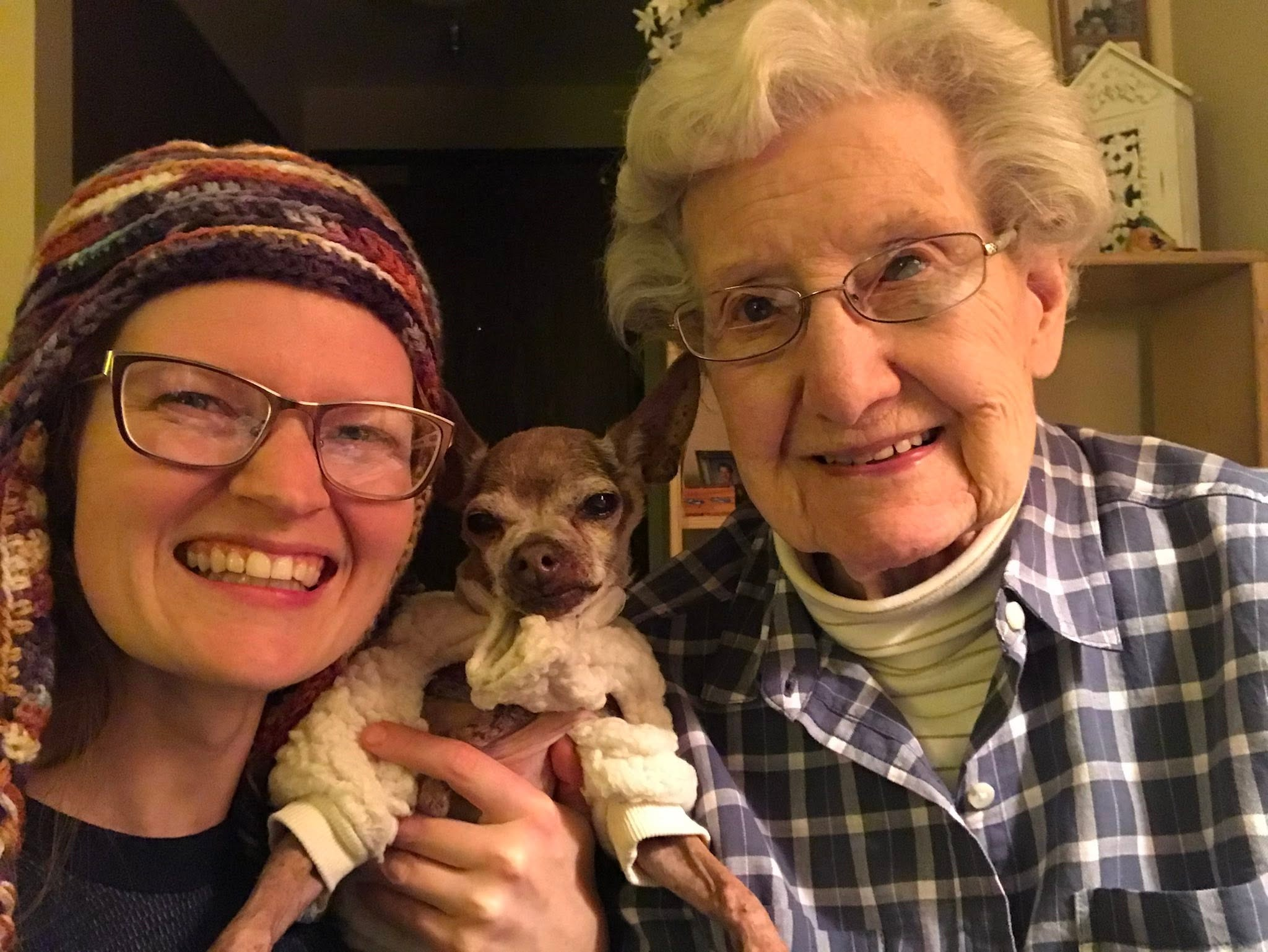 Clarice smiling beside a loved one and a small dog