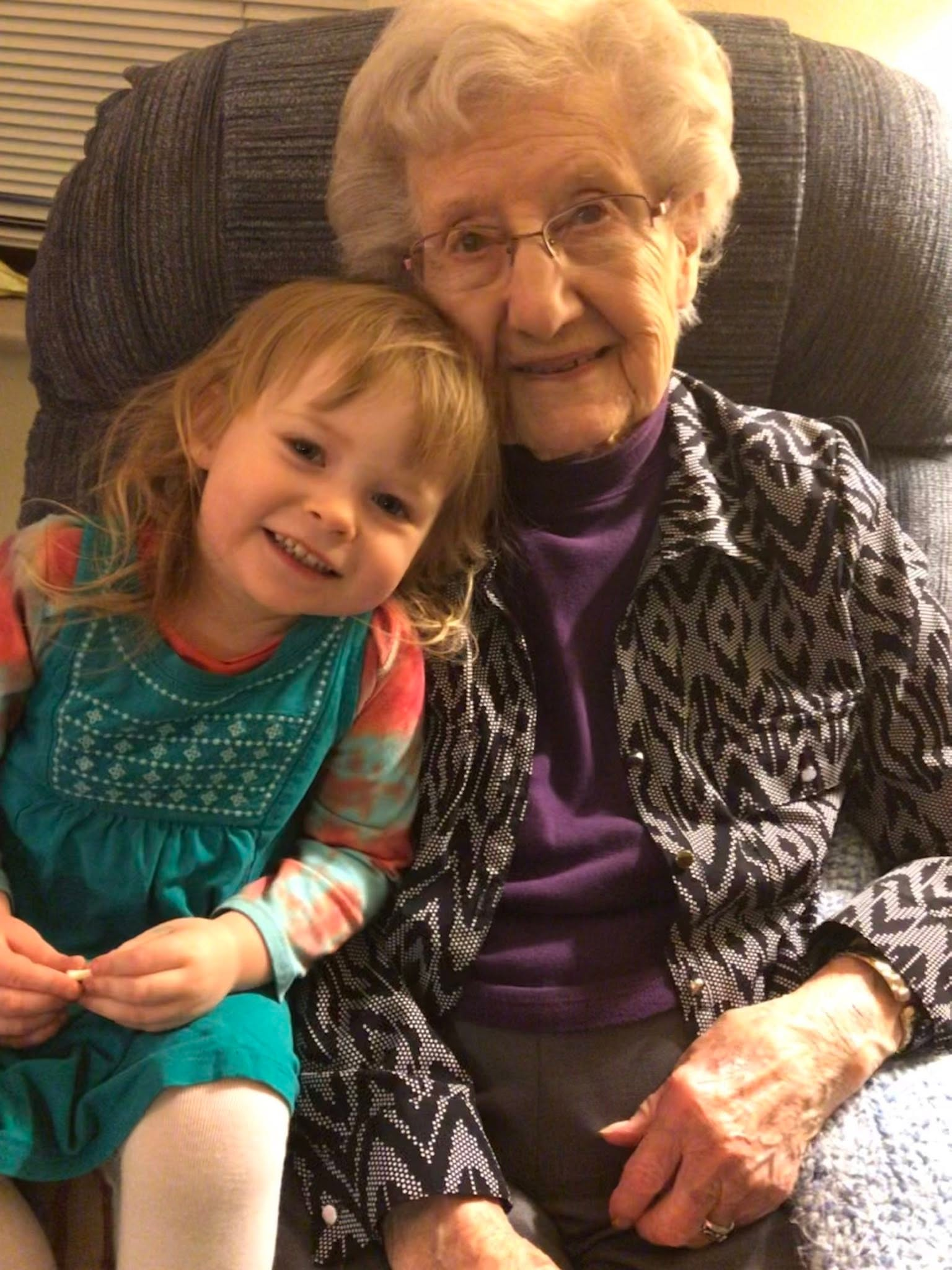 Clarice seated with a young girl leaning against her