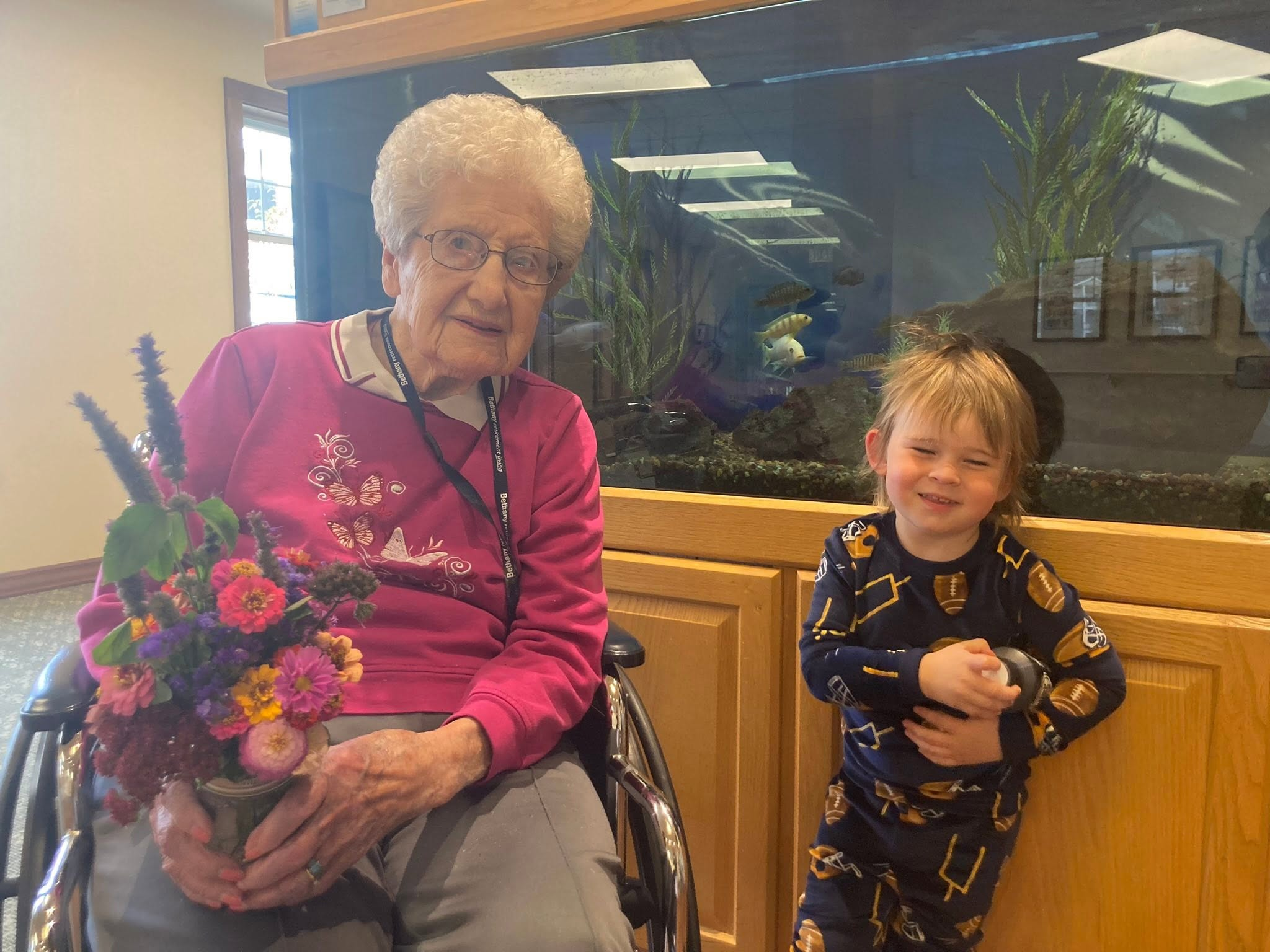Clarice holding flowers beside a smiling child