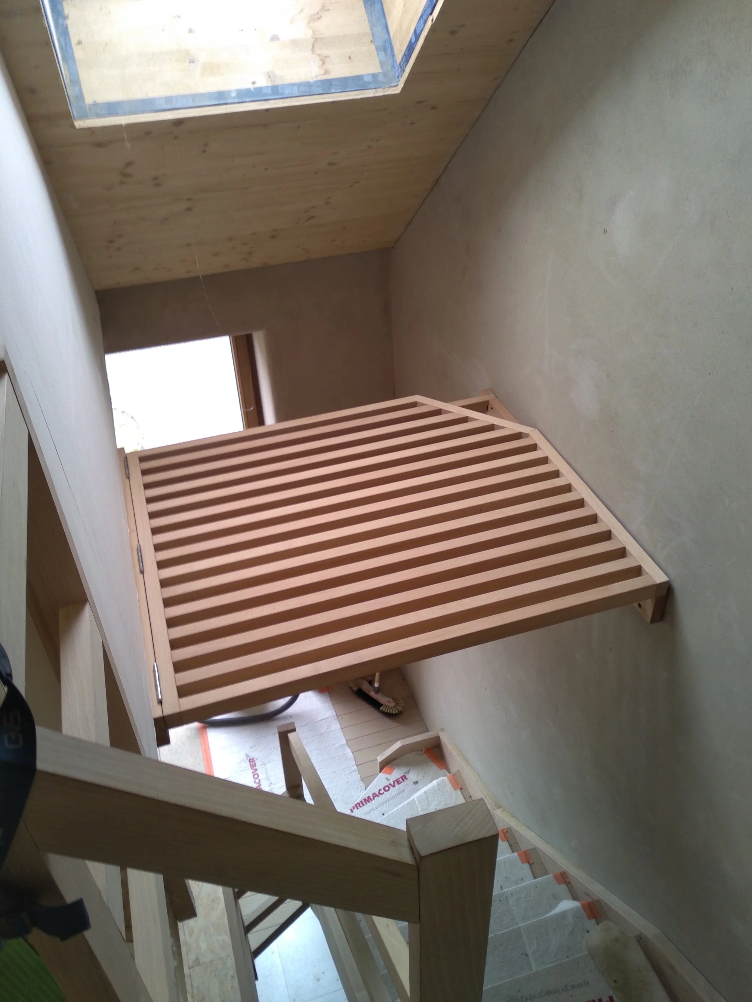 Une échelle en bois menant à un plateau en bois de partie supérieure d'une construction en cours.