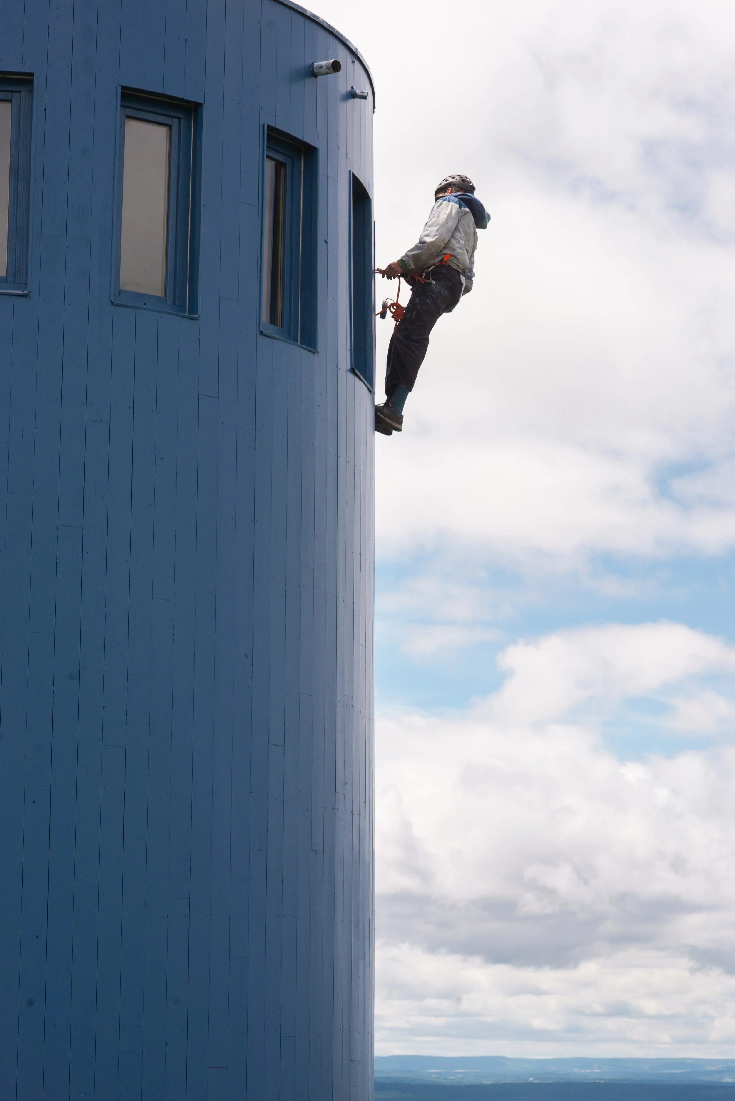 Une monteur et cordiste repeint l'extérieur du "Phare" de Gloria Friedman lors de sa rénovation dans le cadre de la "Ligne du Partage des Eaux" pour le Parc Naturel Régional des Monts d'Ardèche.