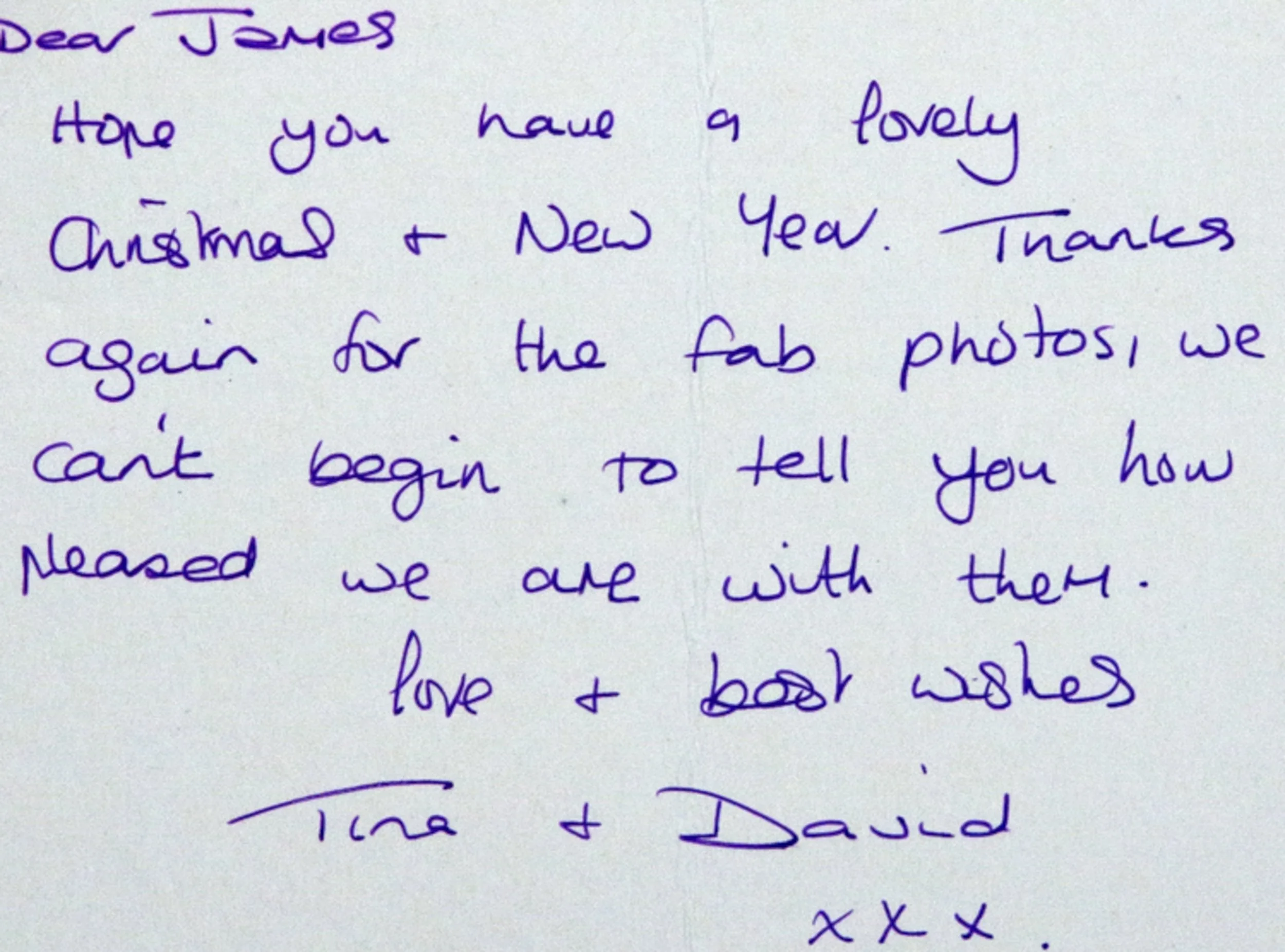 A handwritten note on white paper addressed to James, expressing holiday wishes and gratitude for photos, signed by Tina and David.