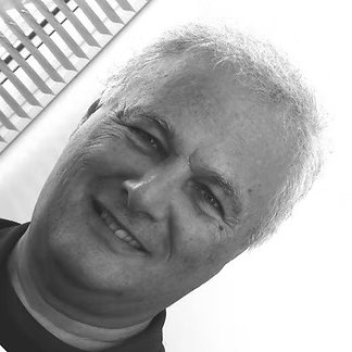 Close-up of an older man with light-colored hair smiling at the camera