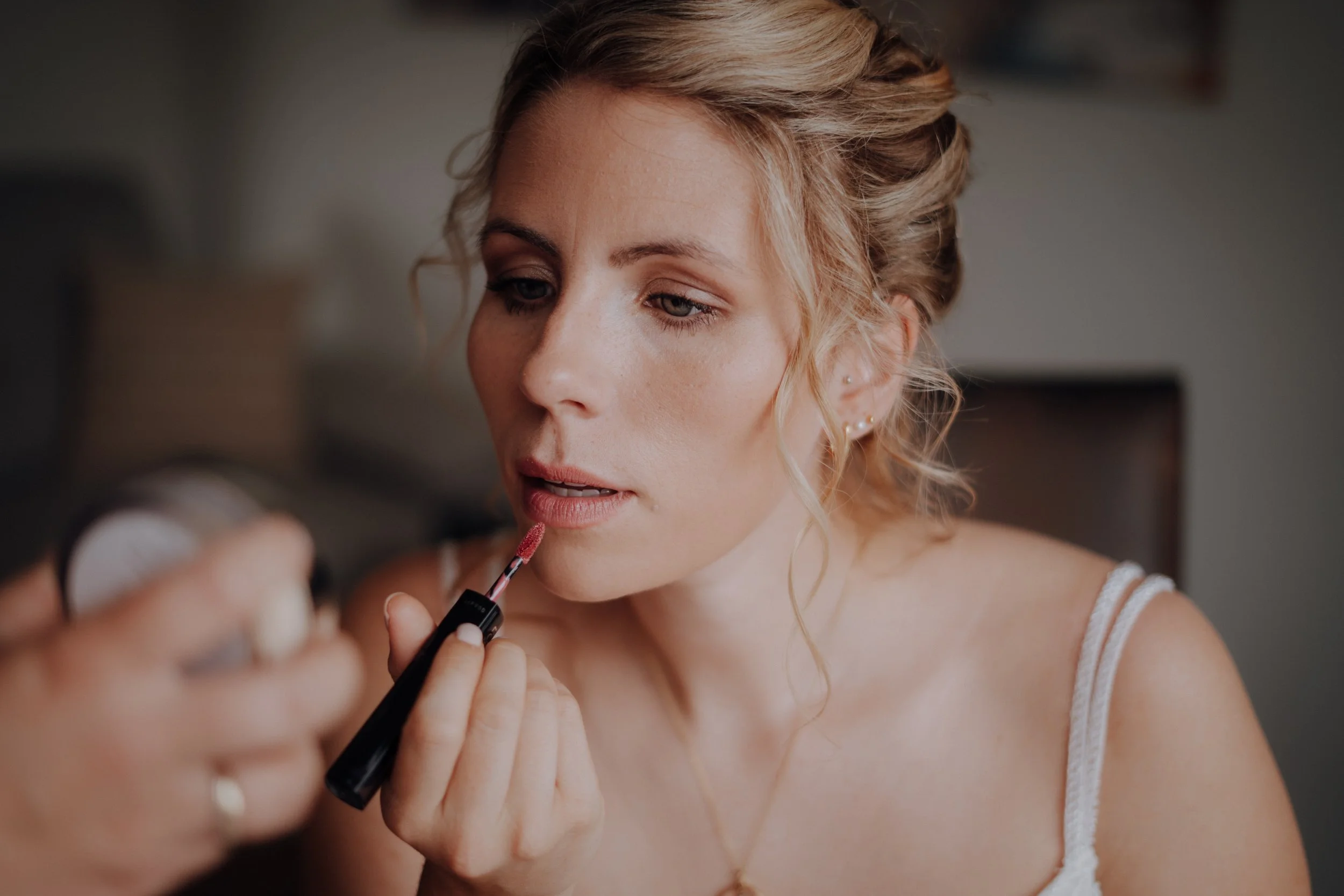 Frau beim Auftragen von Lippenstift mit einem Pinsel, Nahaufnahme.