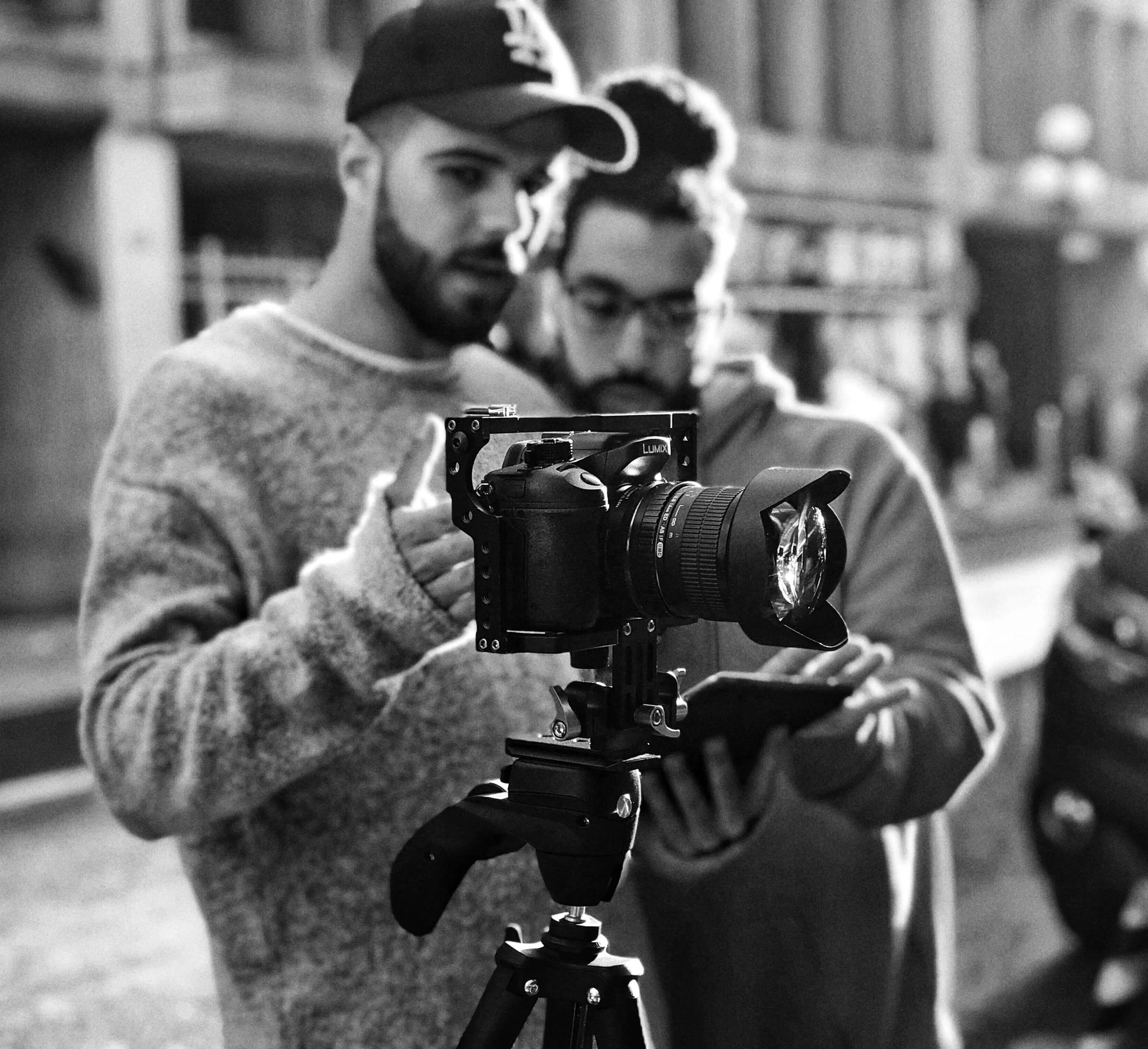 Deux hommes regardant une caméra sur un trépied dans une rue urbaine