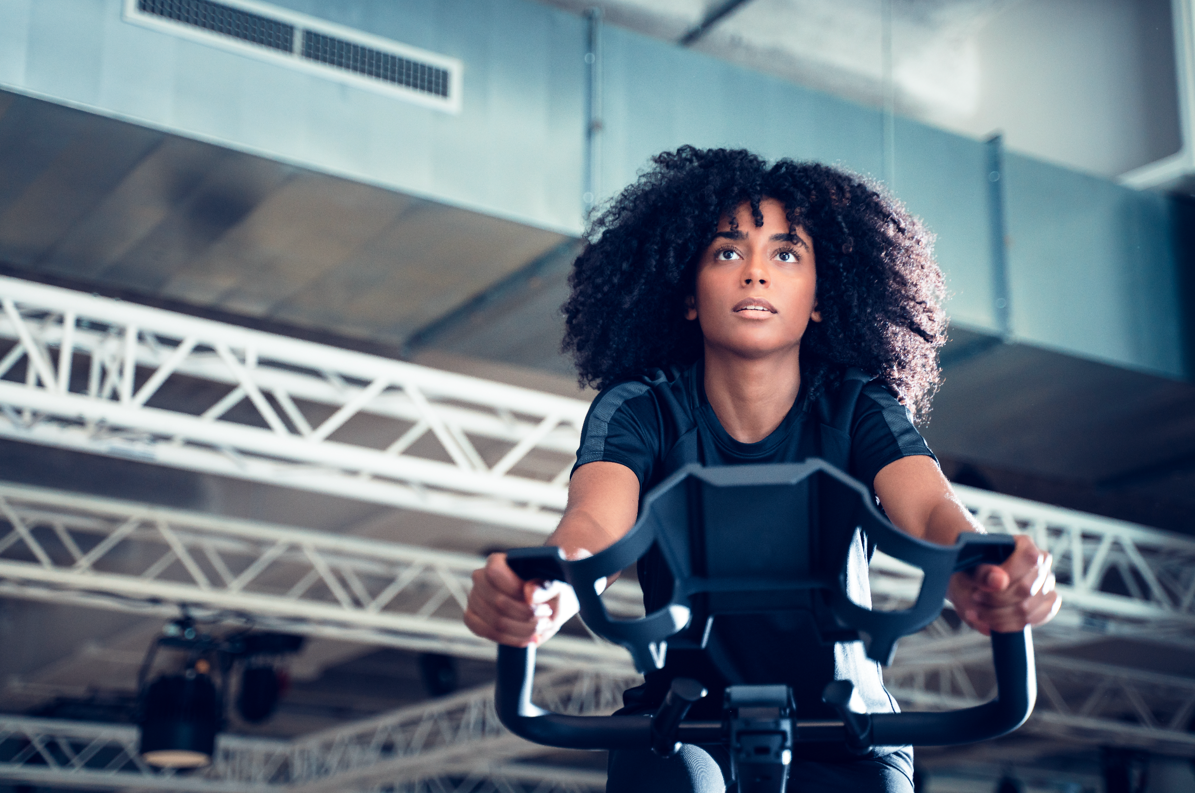 Femme sportive faisant du vélo d'intérieur dans une salle de sport.