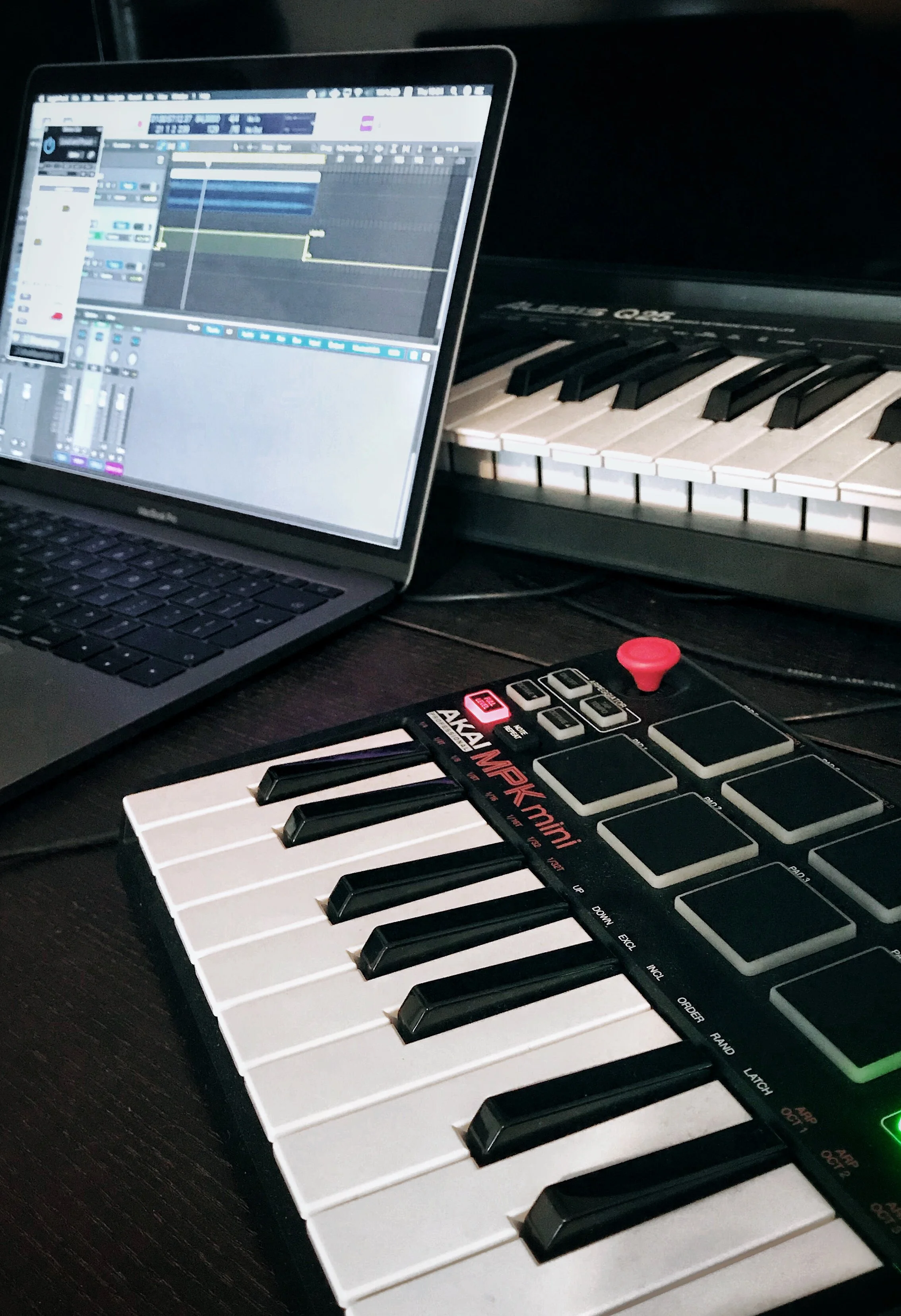 Une configuration de musique comprenant un ordinateur portable affichant un logiciel de production musicale, un clavier de piano numérique et un autre clavier de piano.