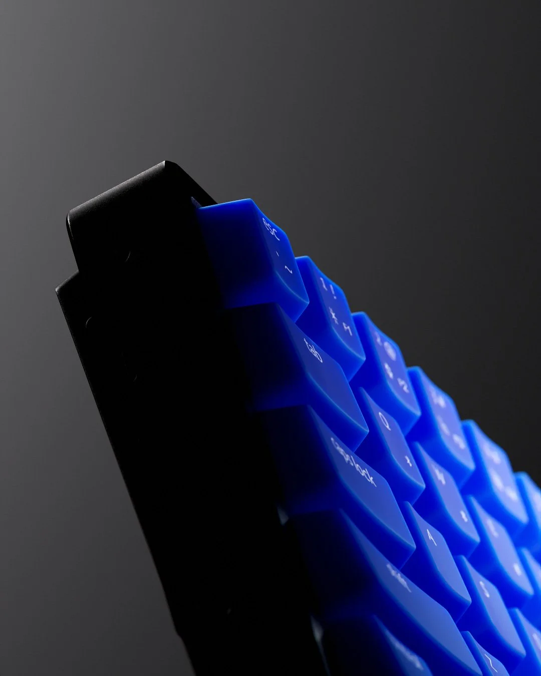 Tastiera retroilluminata con tasti blu, vista laterale in un'illuminazione soffusa.