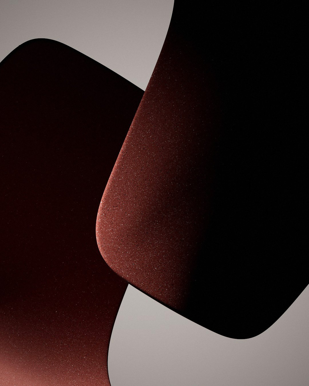 Dettaglio artistico di forme astratte nere, rosse e grigie con superfici lisce e spolverate, creando un design moderno e minimale.