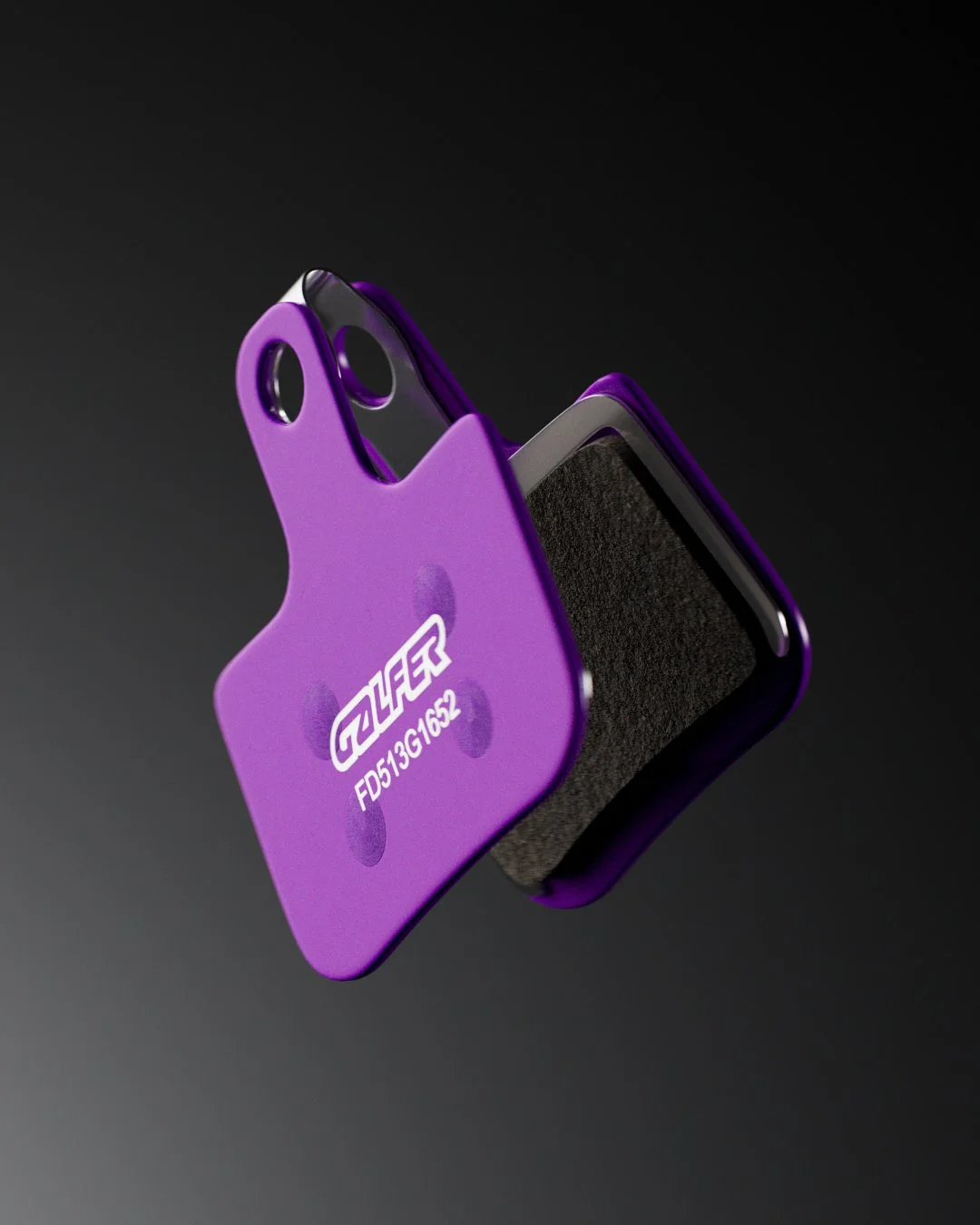 Freno a disco in viola con leggere marcature e dettagli tecnici, appoggiato su superficie nera.