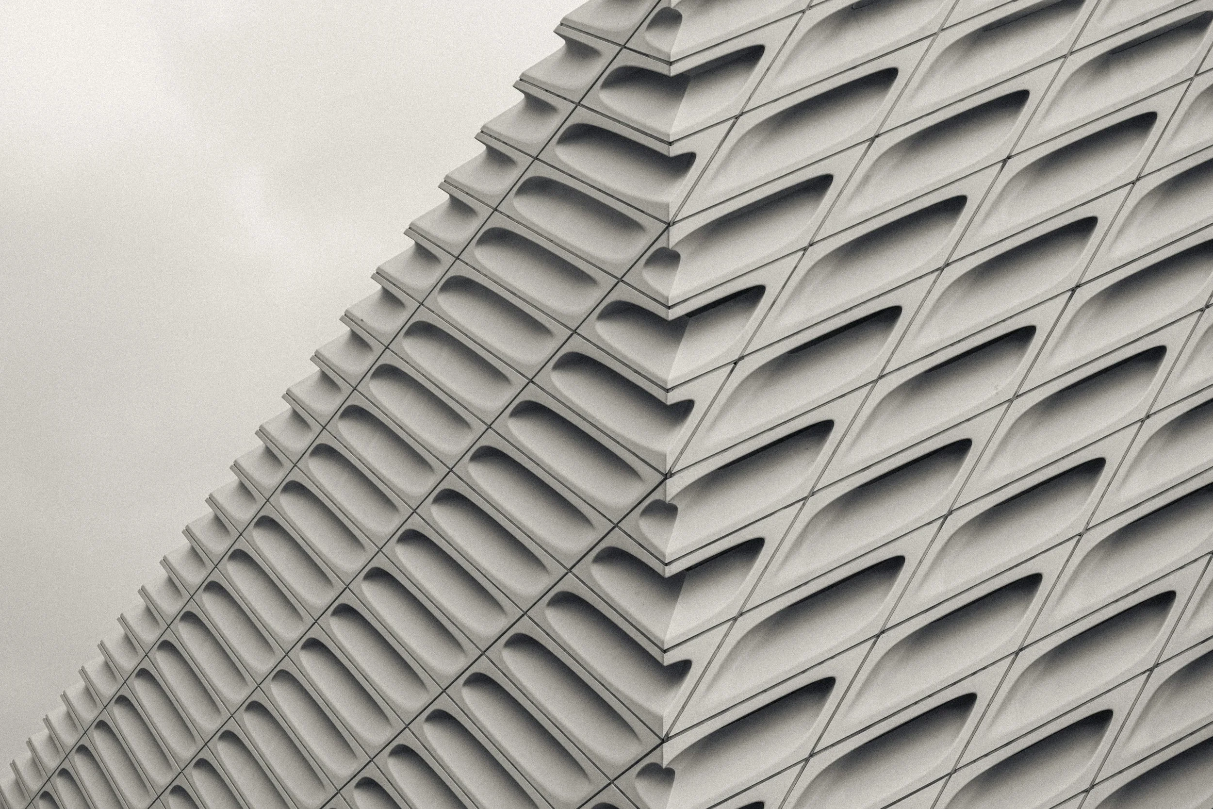 Aerial view of a dam releasing water with a forested area on one side and a large body of still water on the other.