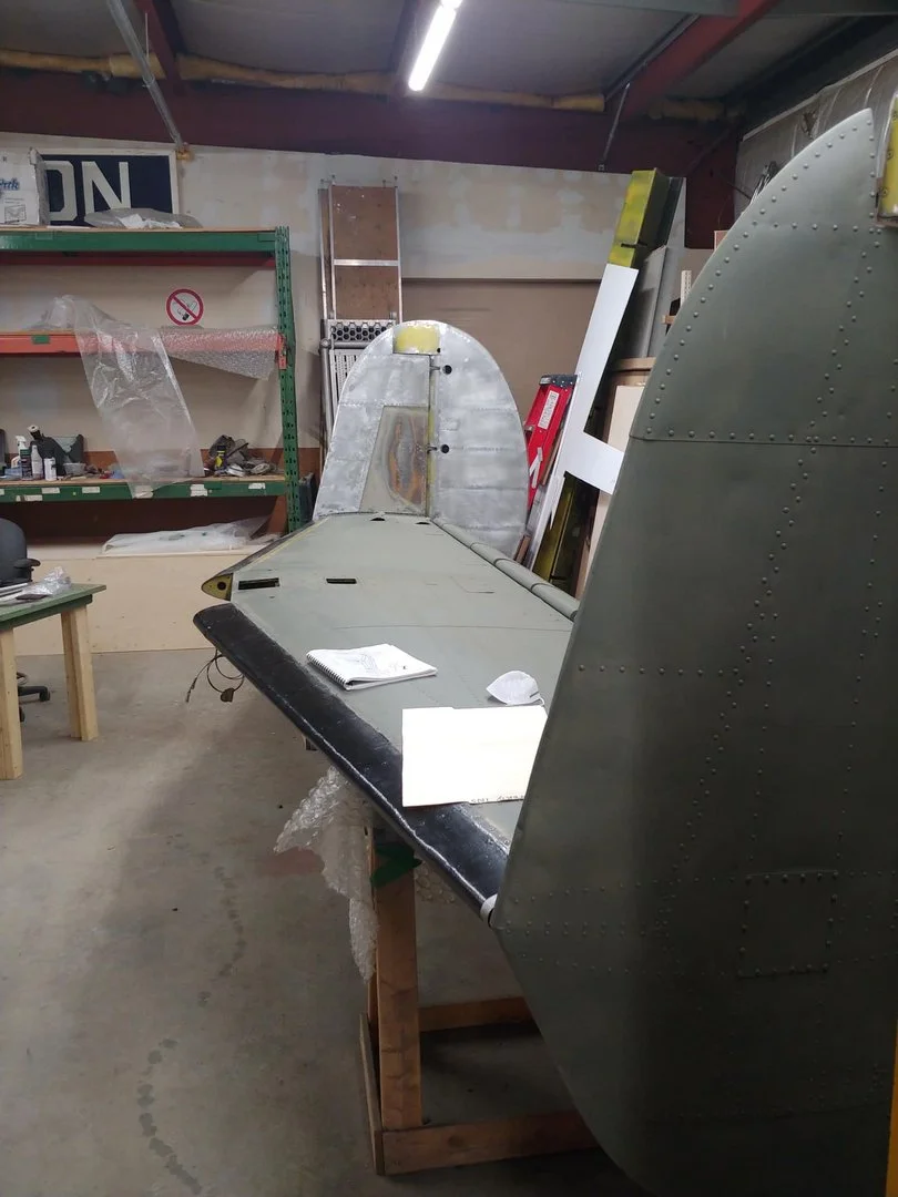 Darren and Martin are fitting the vertical stabilizers and rudders to make sure all the pieces line up. Note the shiny aluminum piece on the starboard stab. Darren had to remove the damaged piece, manufacture and fit a new panel in place.