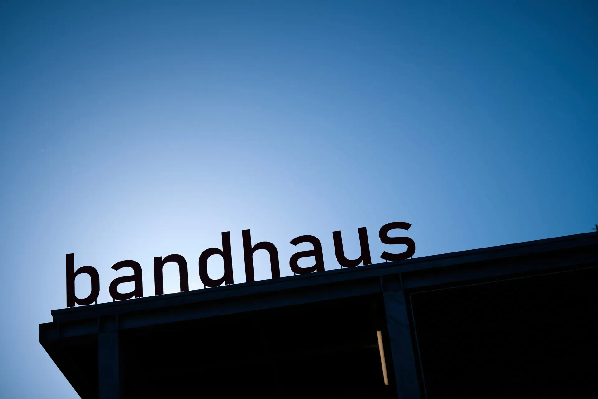 Schild mit der Aufschrift 'bandhaus' gegen blauen Himmel.