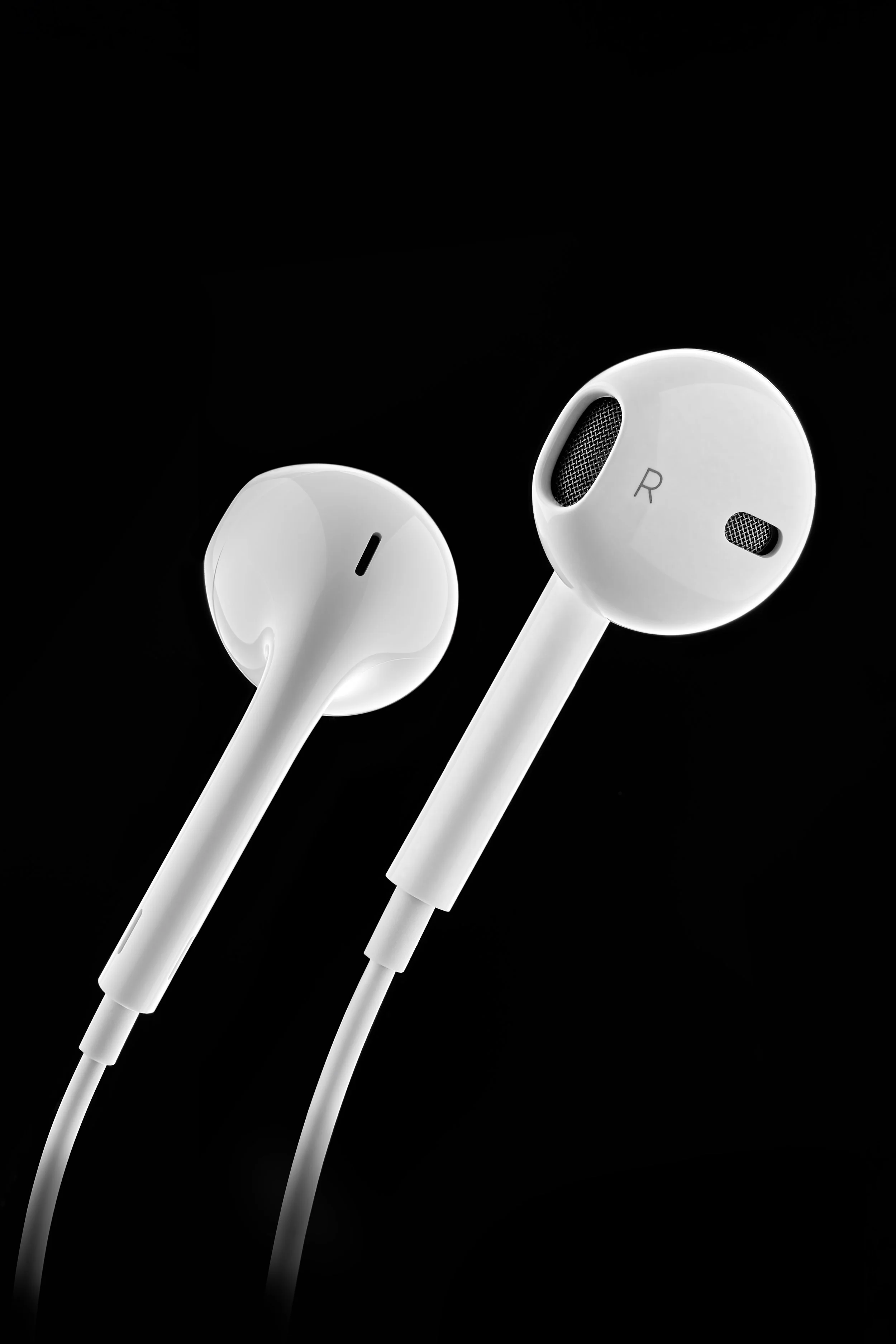 Écouteurs filaires apple blancs contre un arrière-plan noir.