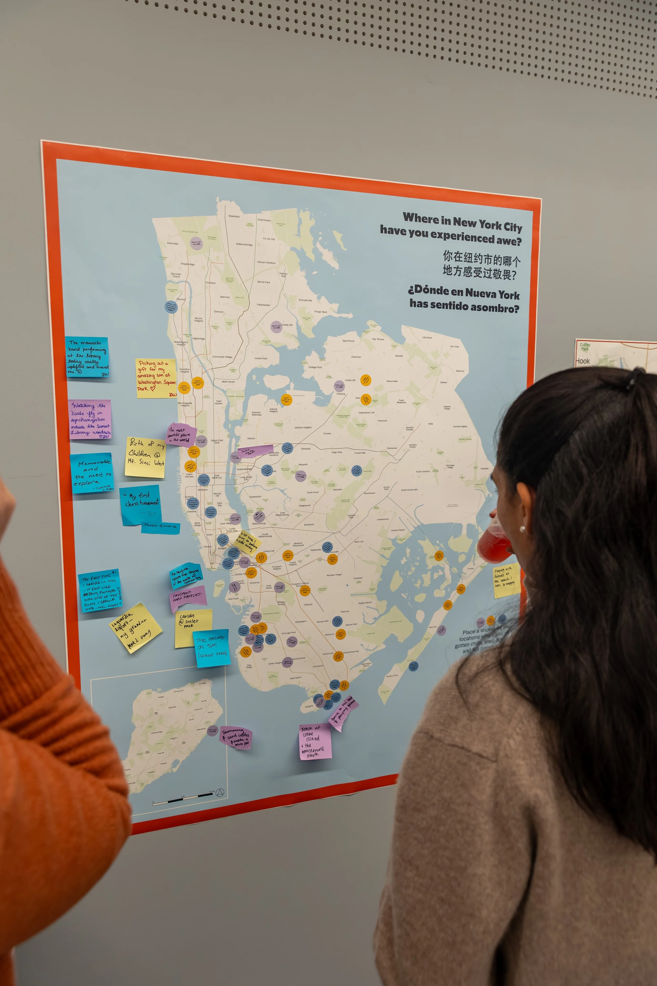 People reviewing a map of New York City with colorful sticky notes and markers, discussing various locations and experiences in the city.