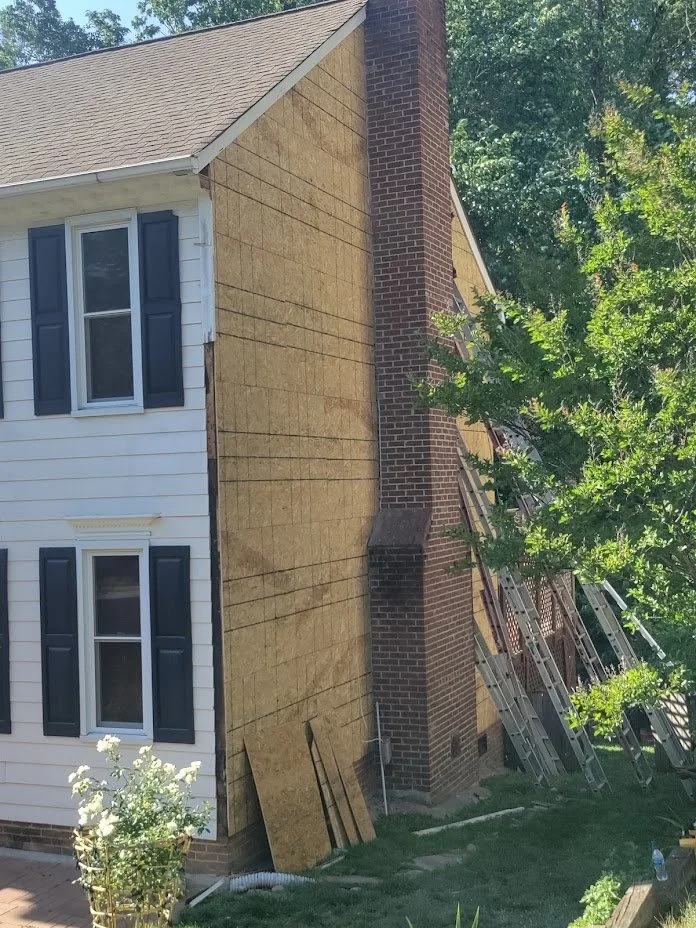 A two story residential home get's fresh plywood before new custom siding is installed in the piedmont area of North Carolina.