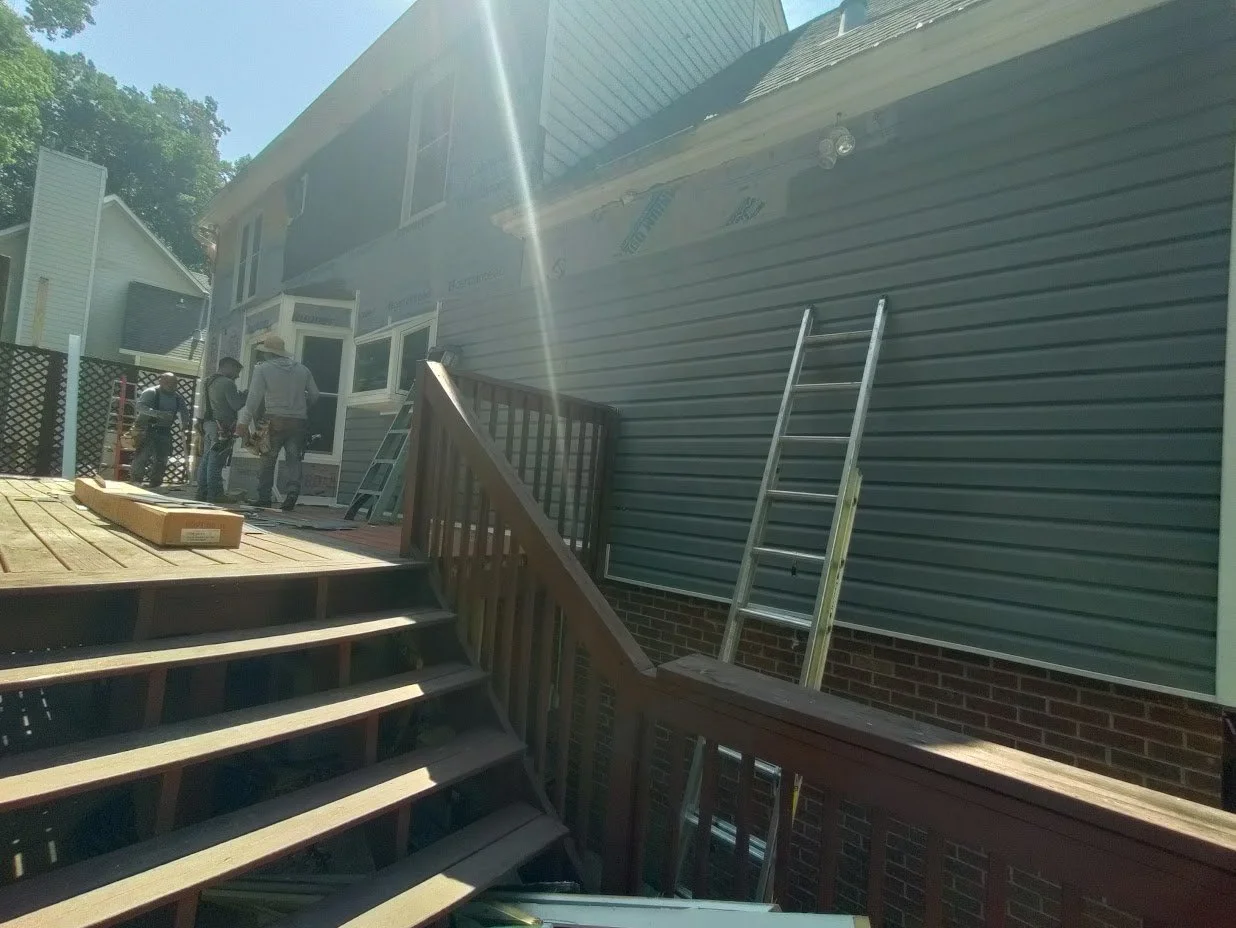 A friendly crew works on a new siding install for a family's home.