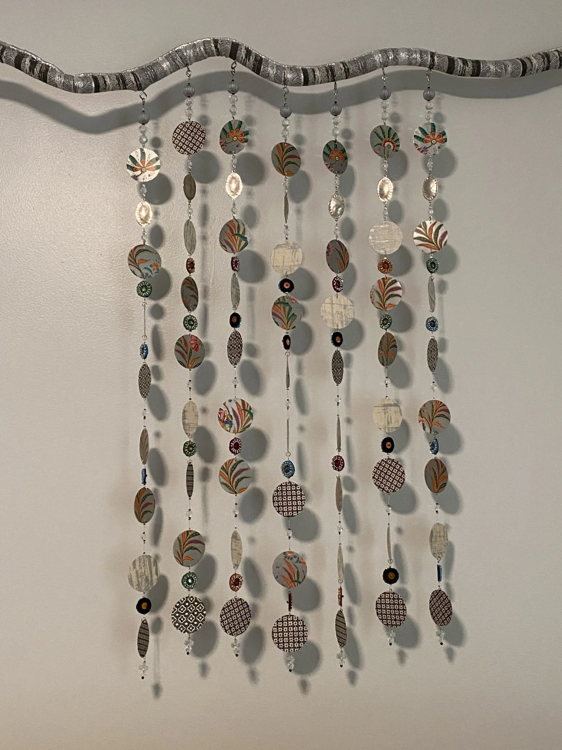 Quiet Chimes
6’-2” x 32” x 1.75”
Artist grown Curly Willow branch, metallic fabric, hand-cut Italian paper + assorted paper discs, nylon filament, beads
2021
