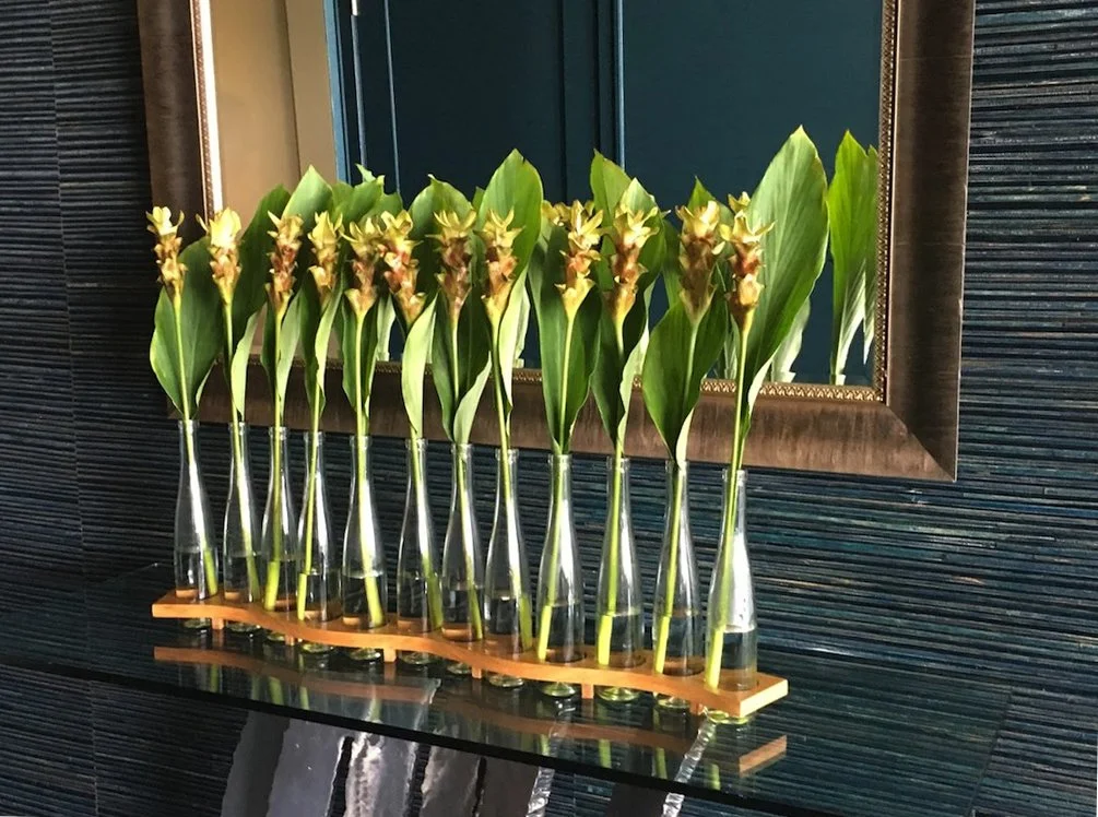 Serpentine Symphony 
3.0′ l x 3.625″ w x 1.75″ h
Hand-crafted wooden base, Ice wine glass bottles (flowers not included)
2016