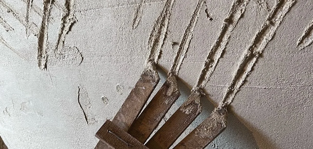 Craftsperson working on heritage techniques such as lime plastering and traditional joinery in a Welsh cottage.