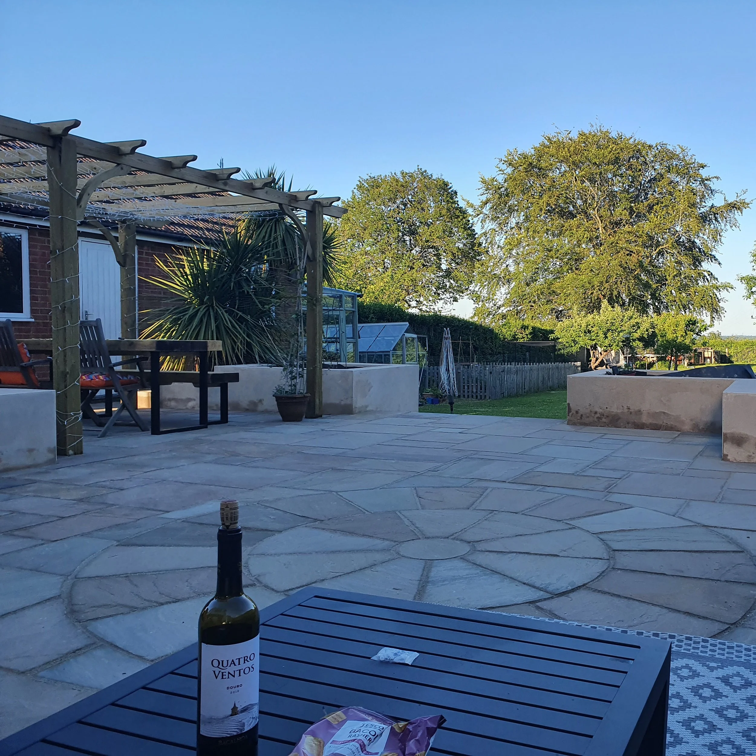 Sandstone patio installation with paving circle and pergola completed in East Sussex by AG Home & Gardens