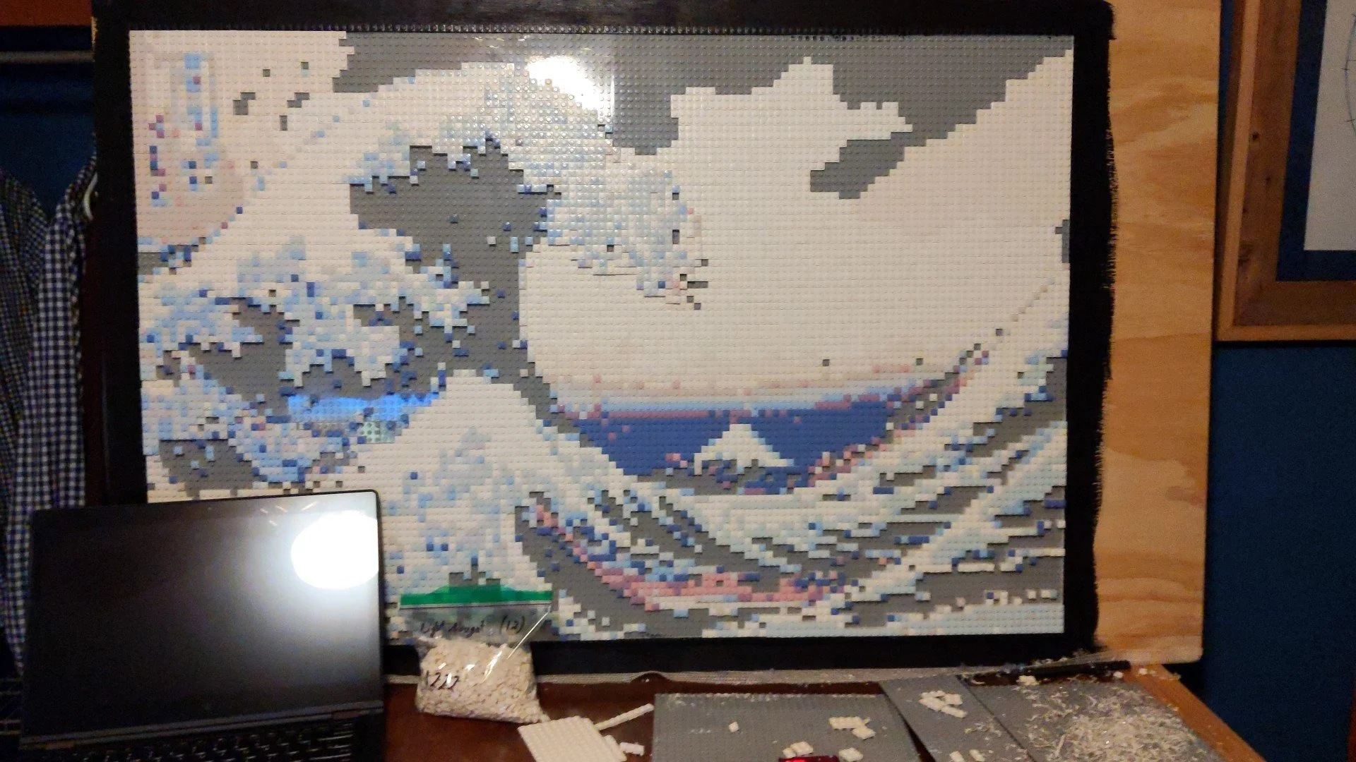 A large mosaic of Mount Fuji and cherry blossoms made with LEGO bricks, displayed on a wall.