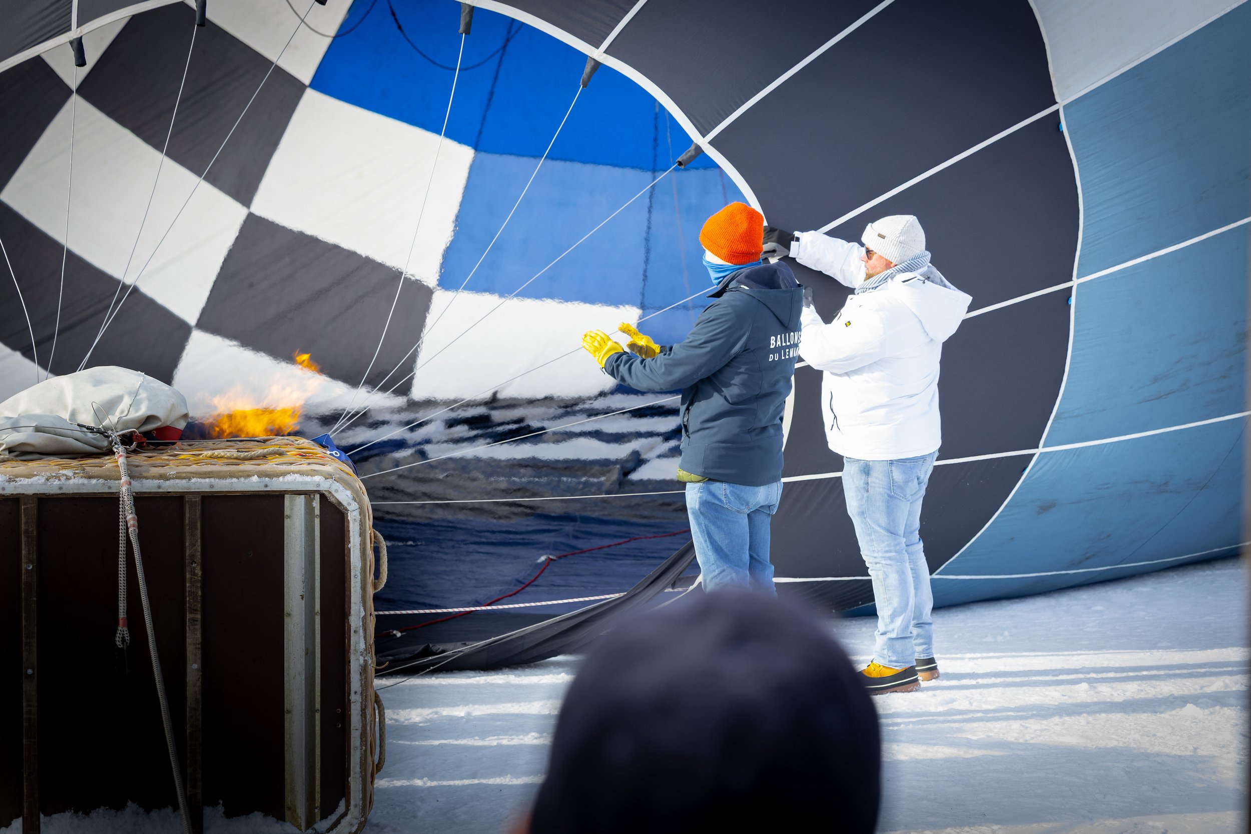 Menschen bei der Vorbereitung eines Heißluftballons auf eisigem Gelände.