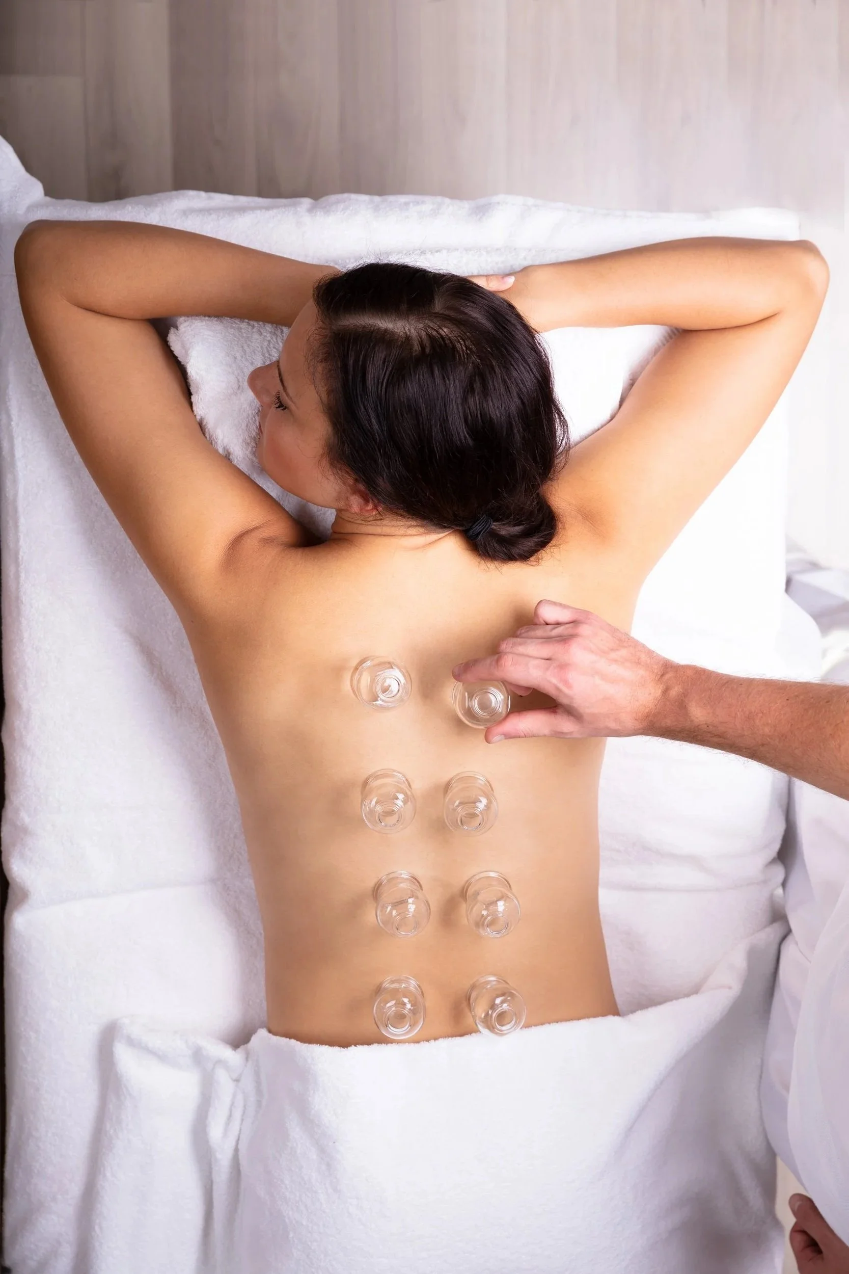 Woman receiving cupping therapy on her back in a spa setting.
