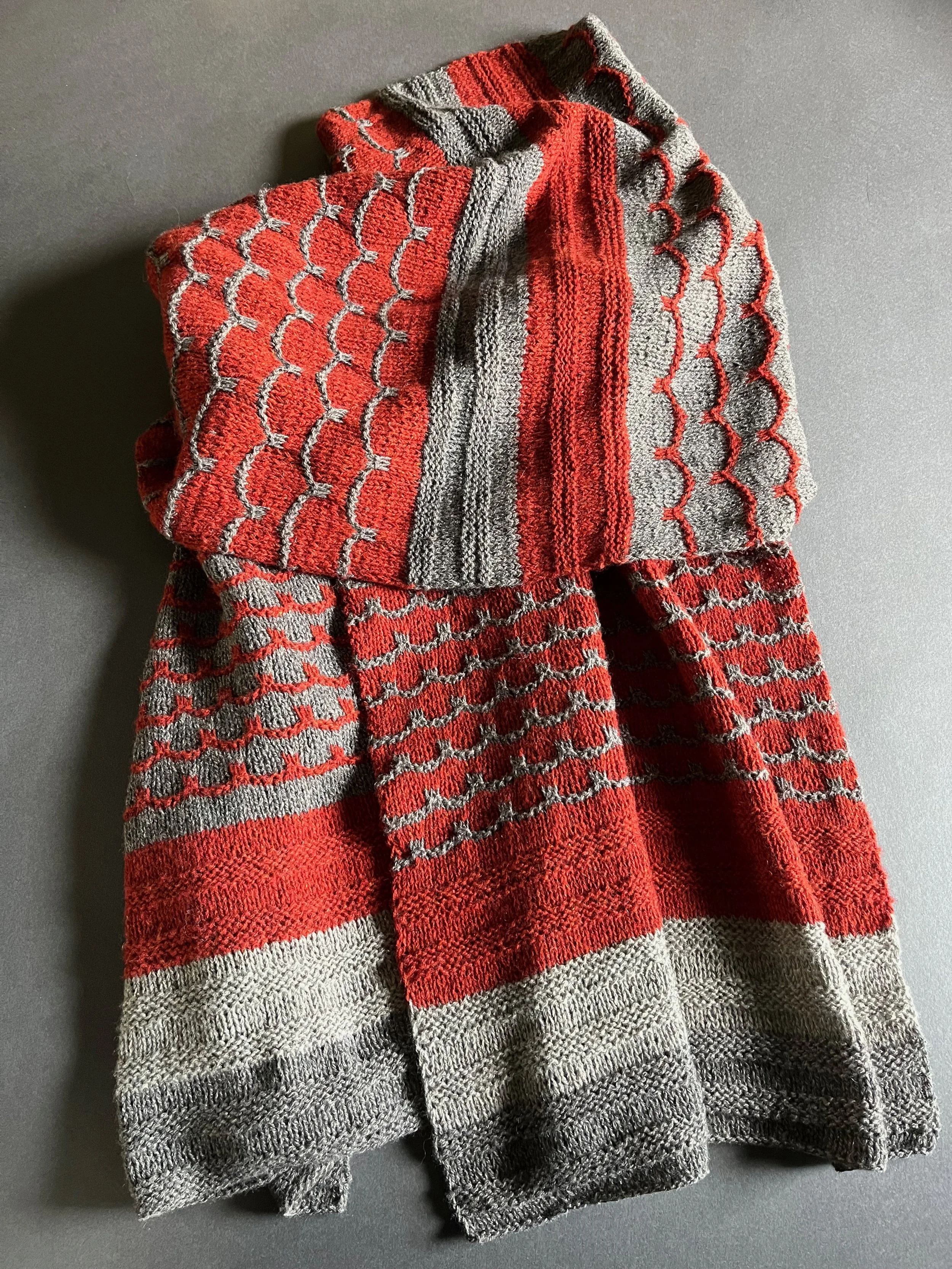 48% silk/36% merino/16% cashmere:
hand knit shawl in alternating sections of scallops and stripes. Can also be worn as a big scarf