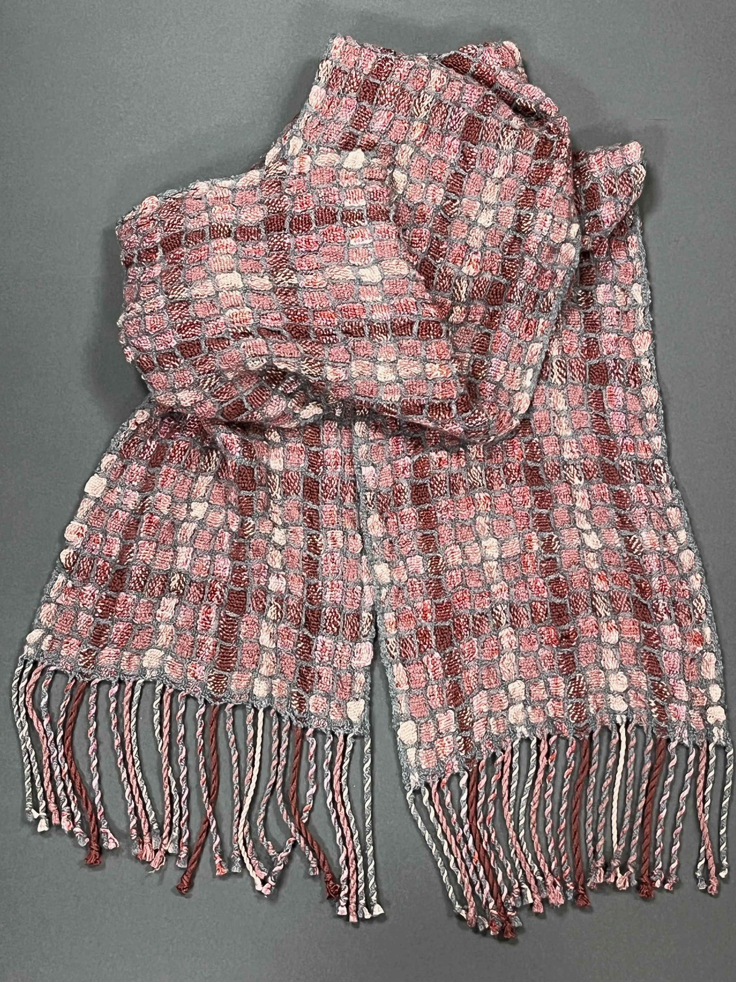 Multiple pink fibers surrounded by a grey 50% silk/50% wool in deflected doubleweave