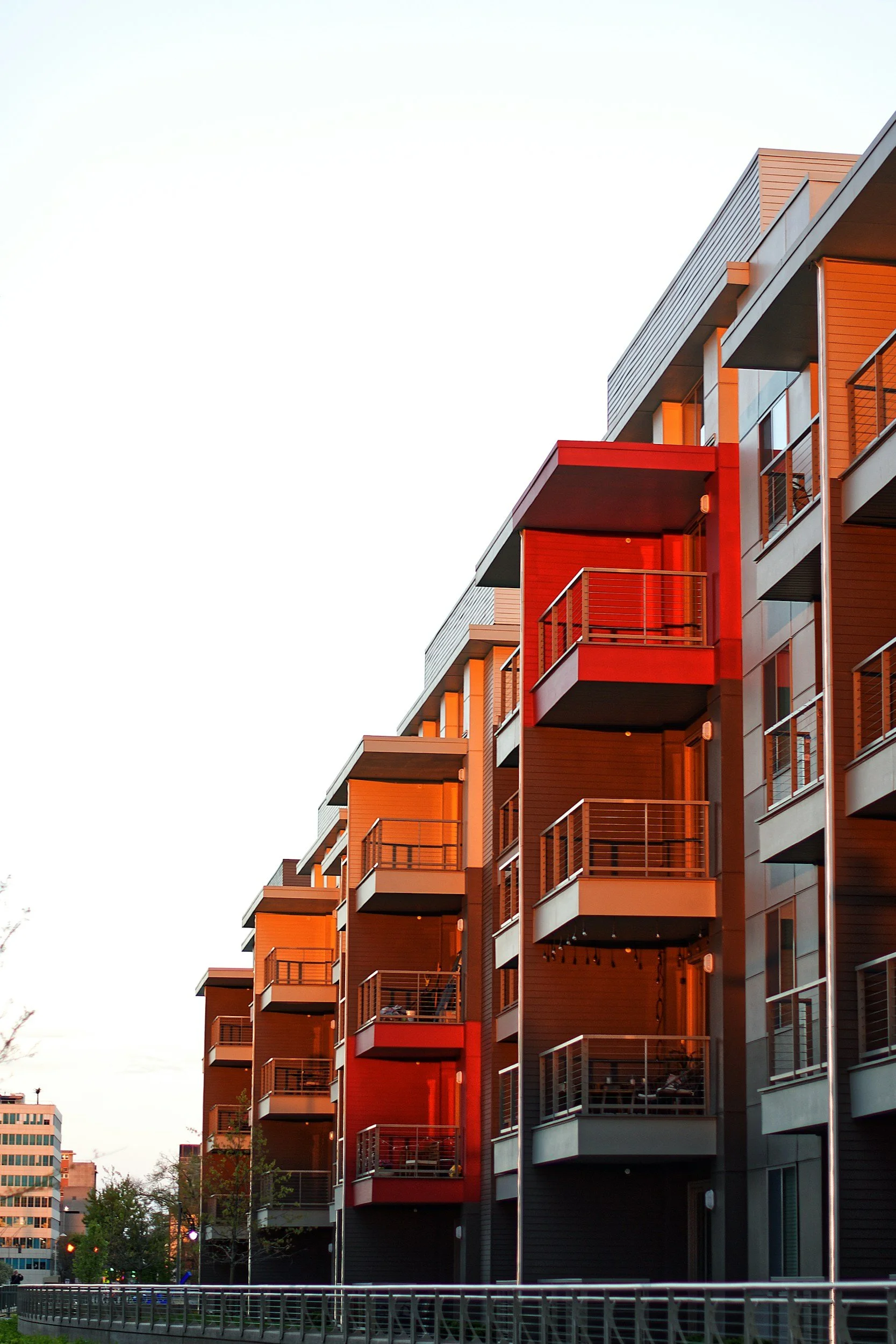 Side angle of red condominium building showing multiple balconies