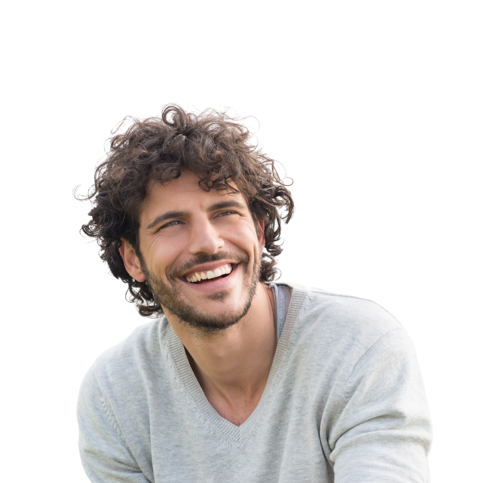 A young man with curly brown hair and a beard, smiling and looking to the side, wearing a light grey sweater.
